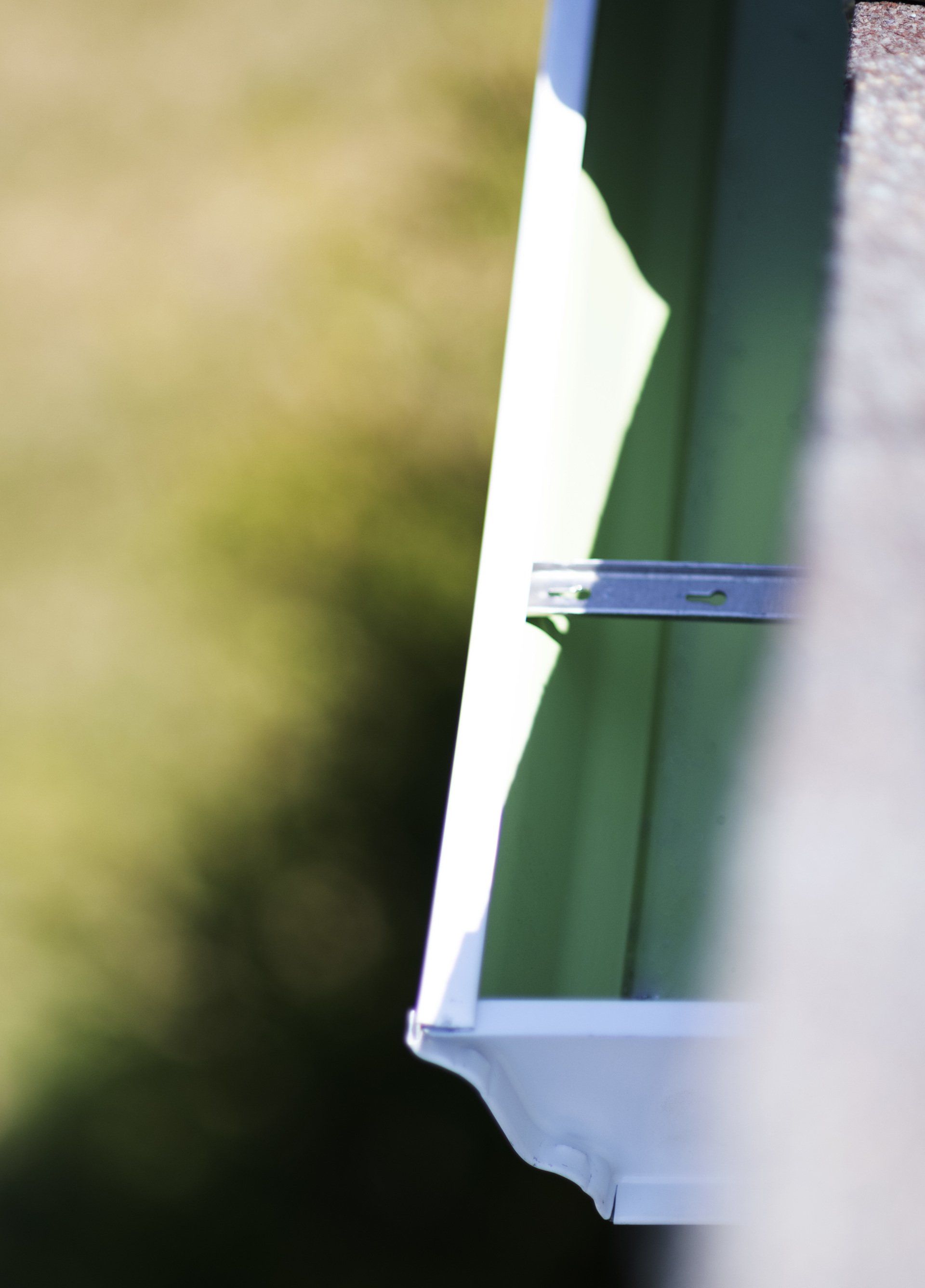 a close up of a green and white gutter on a roof