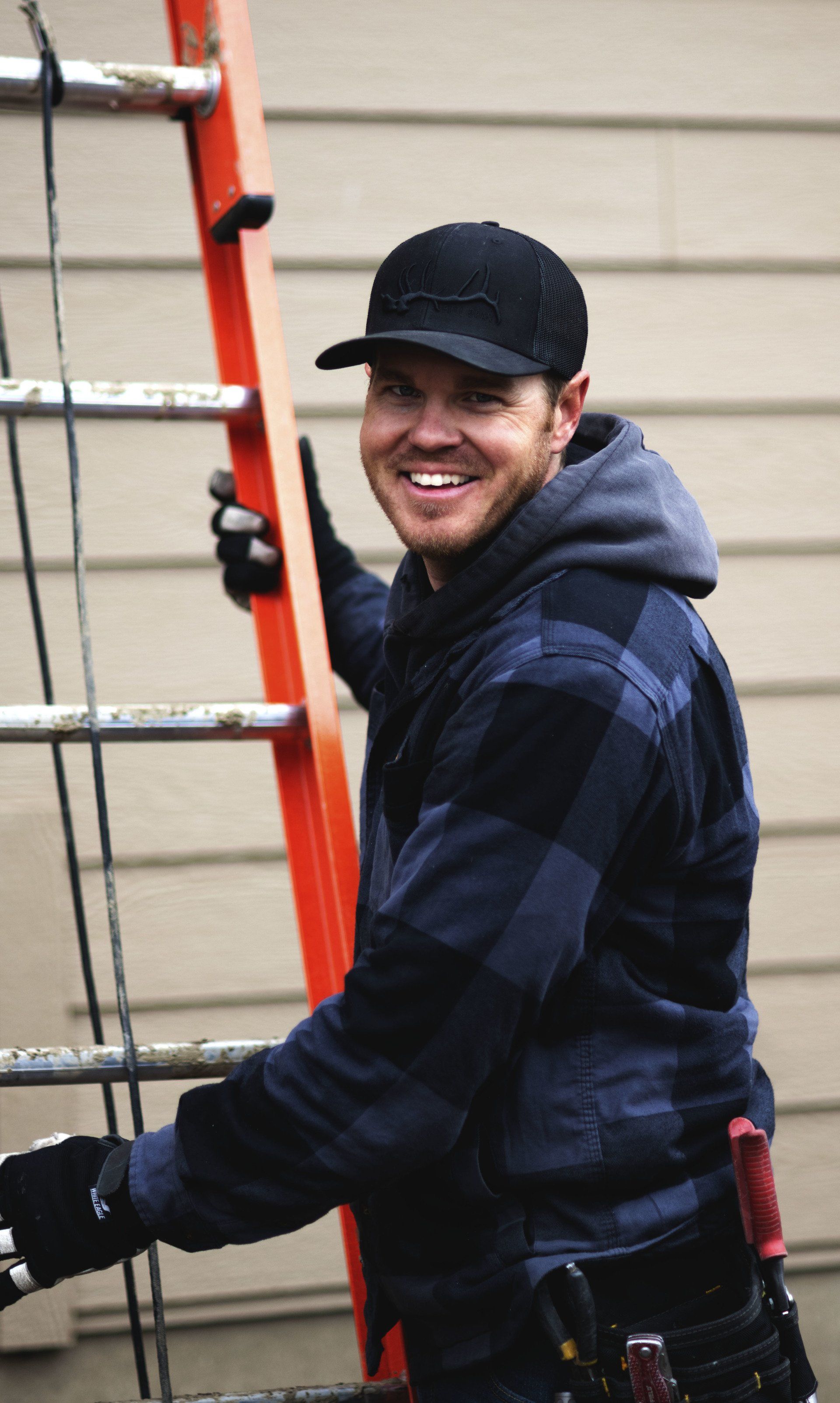 a man is standing on a ladder and smiling .