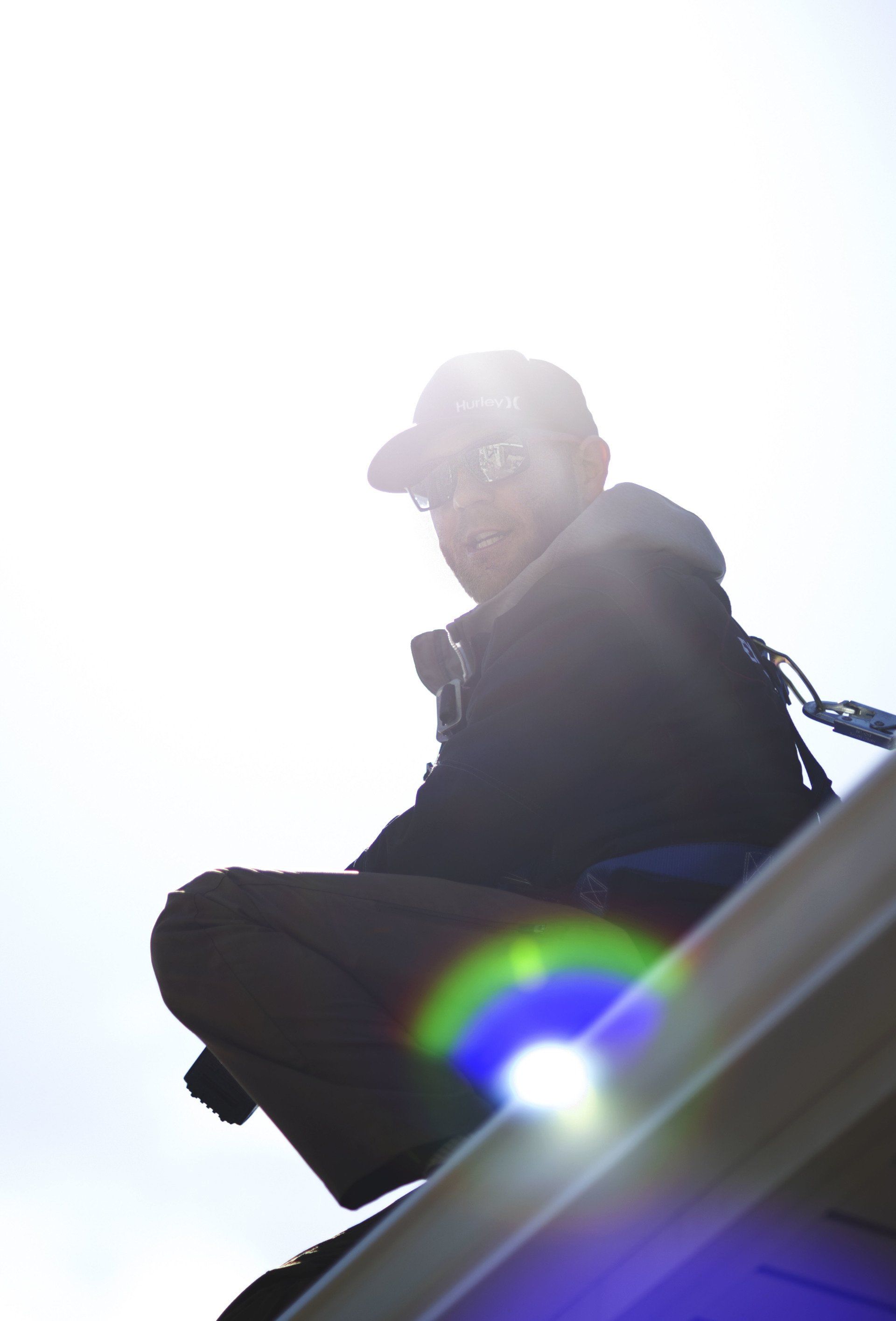 a man in a baseball cap is sitting on a ledge