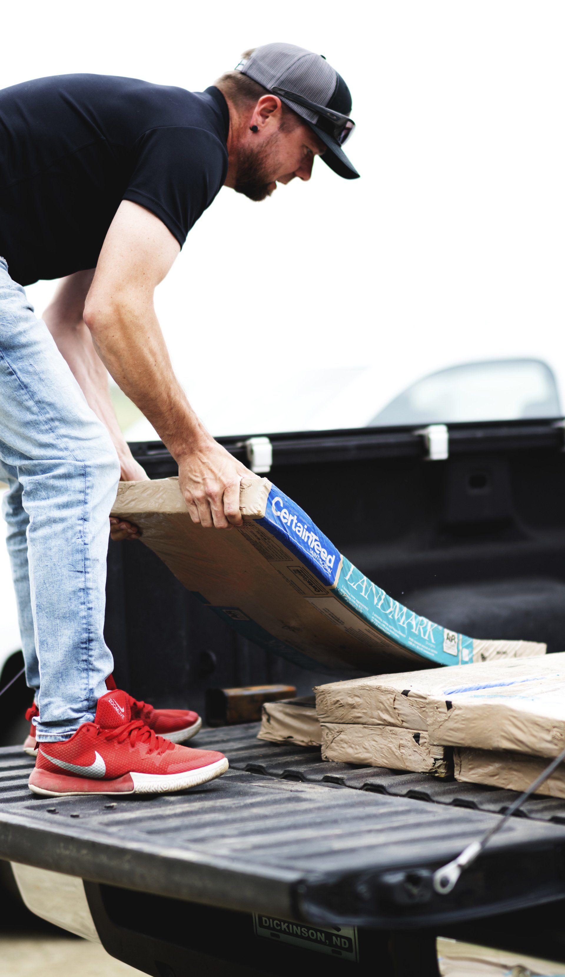 a man is loading a box into the back of a truck .