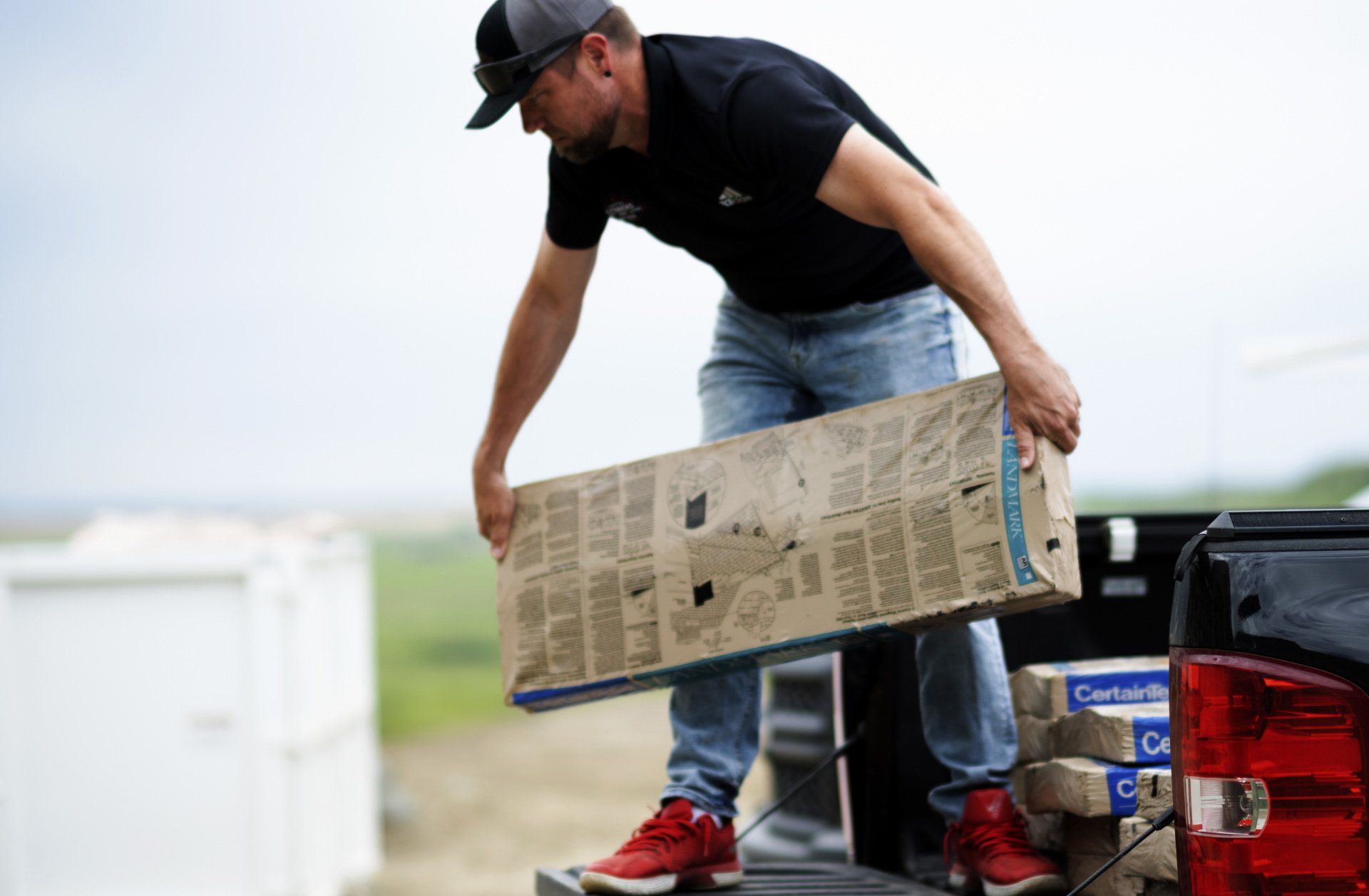 a man is loading a box into the back of a truck .