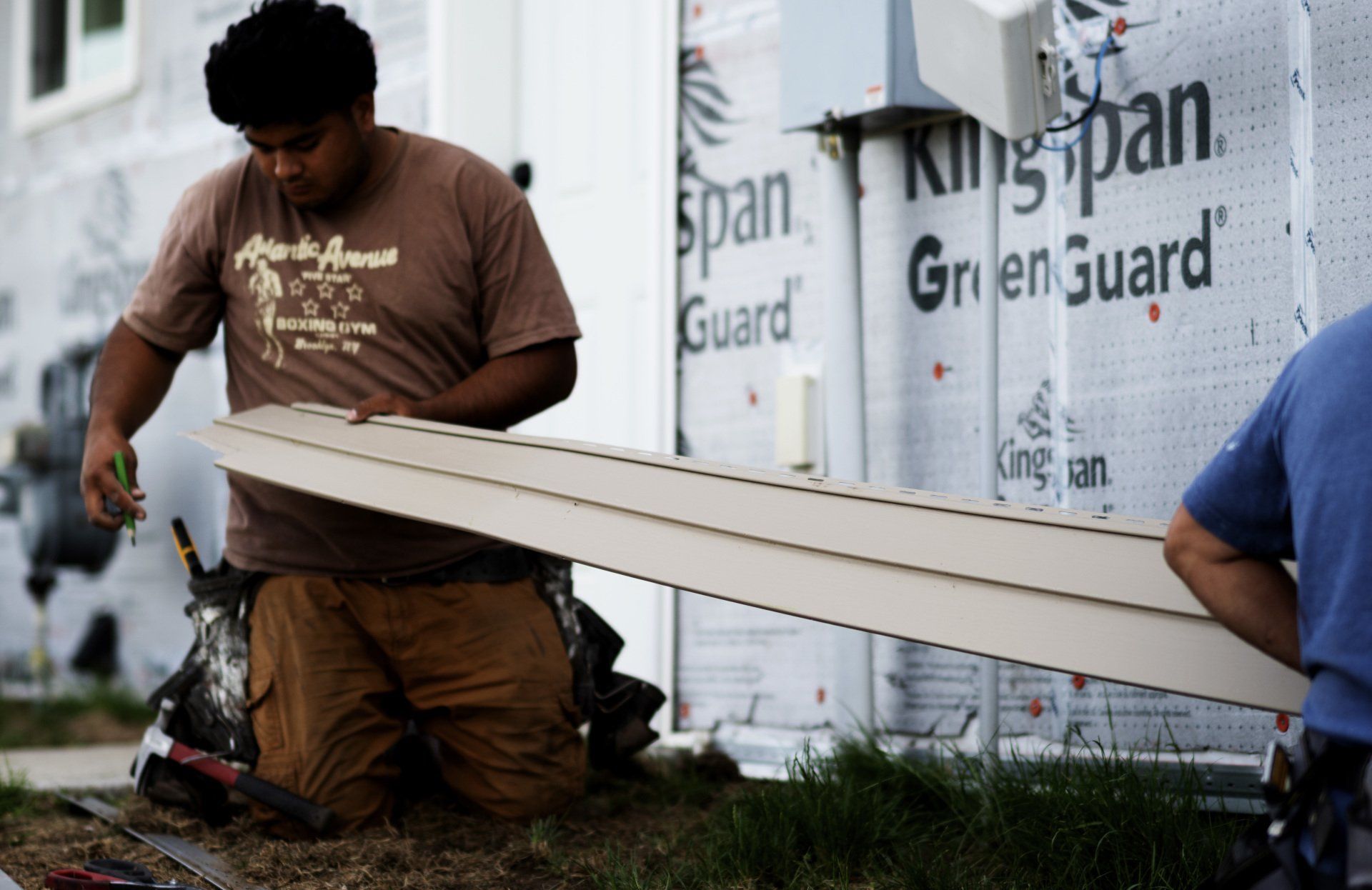 a man is kneeling in front of a kingspan trailer