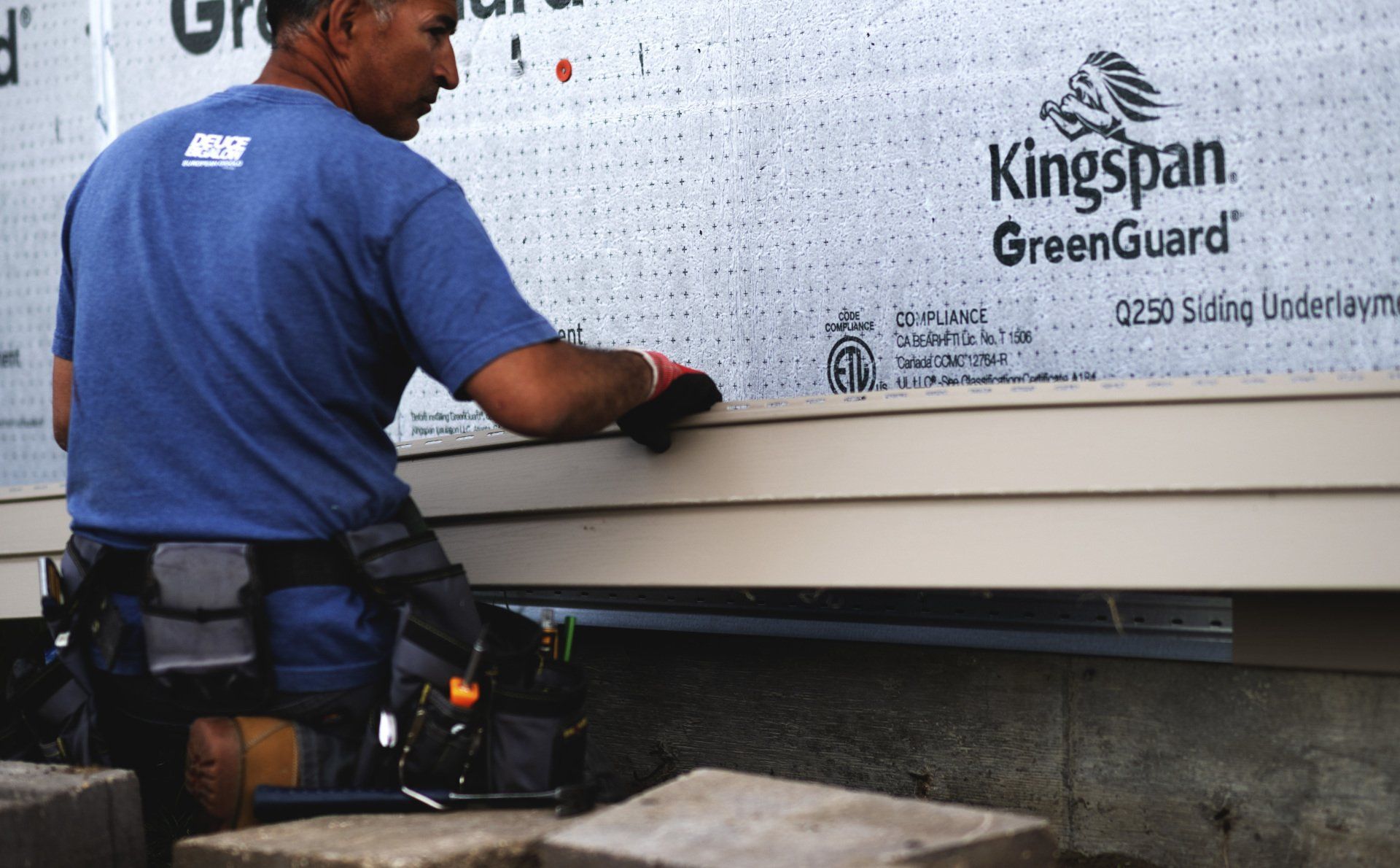 a man is working on a wall with kingspan greenguard