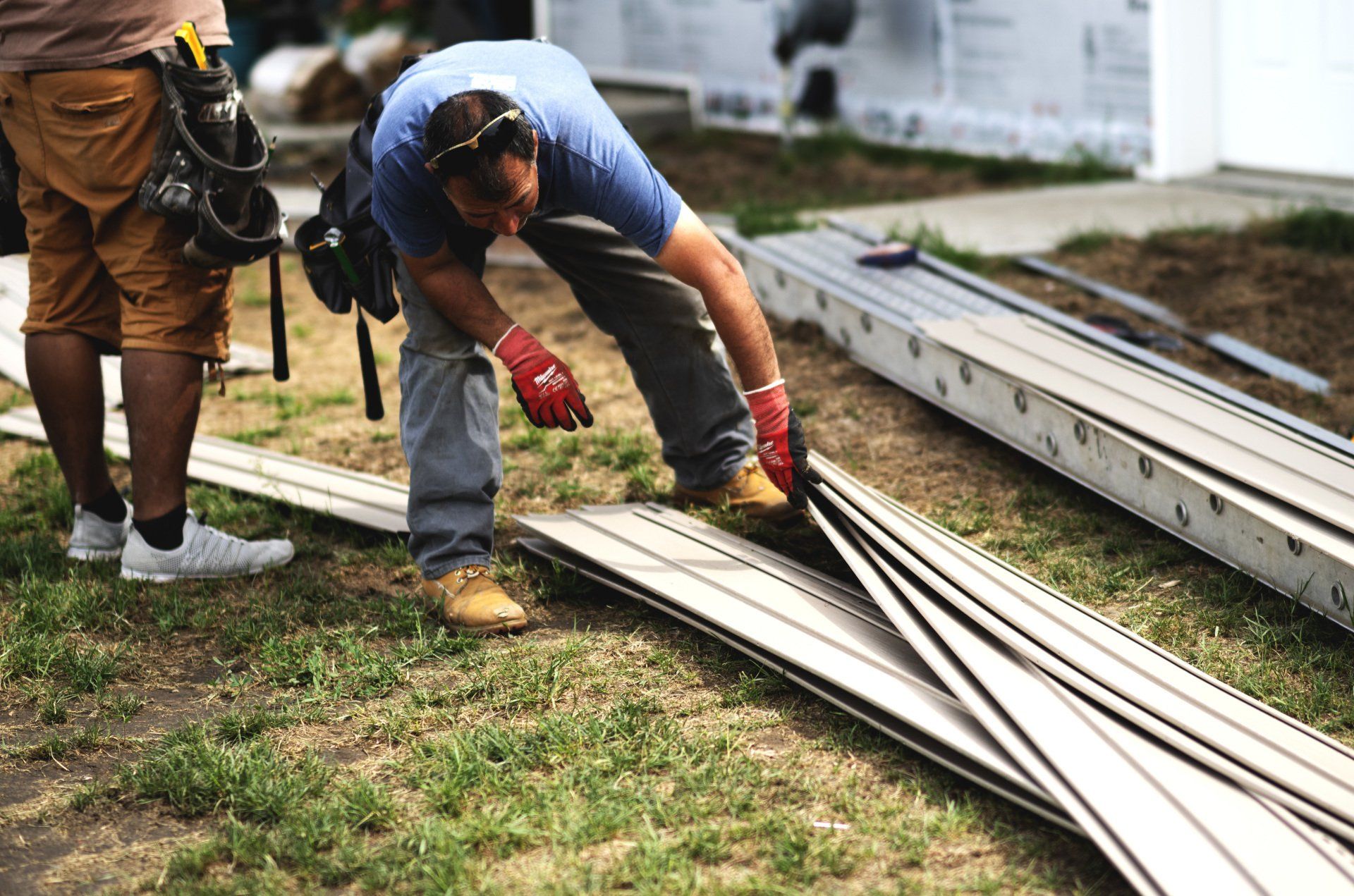 a man is working on a roof with a ladder in the background .