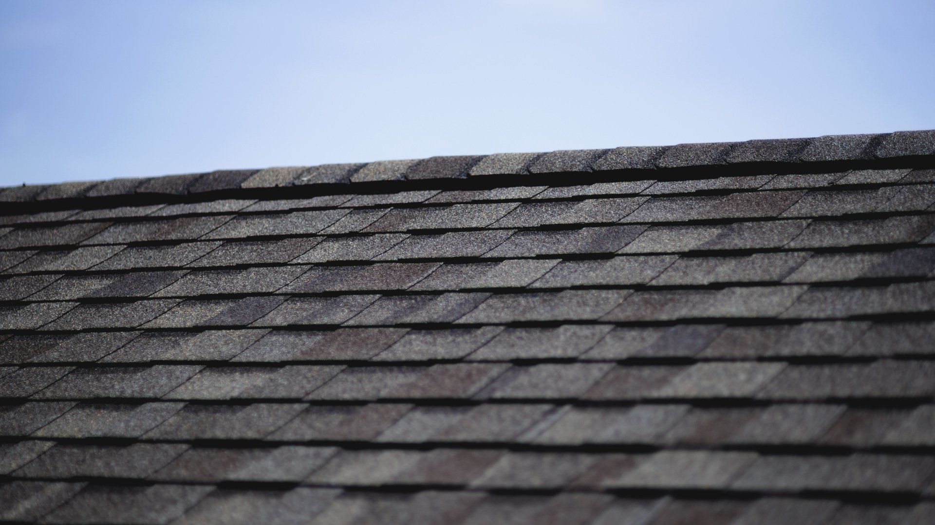 a close up of a roof with shingles against a blue sky .