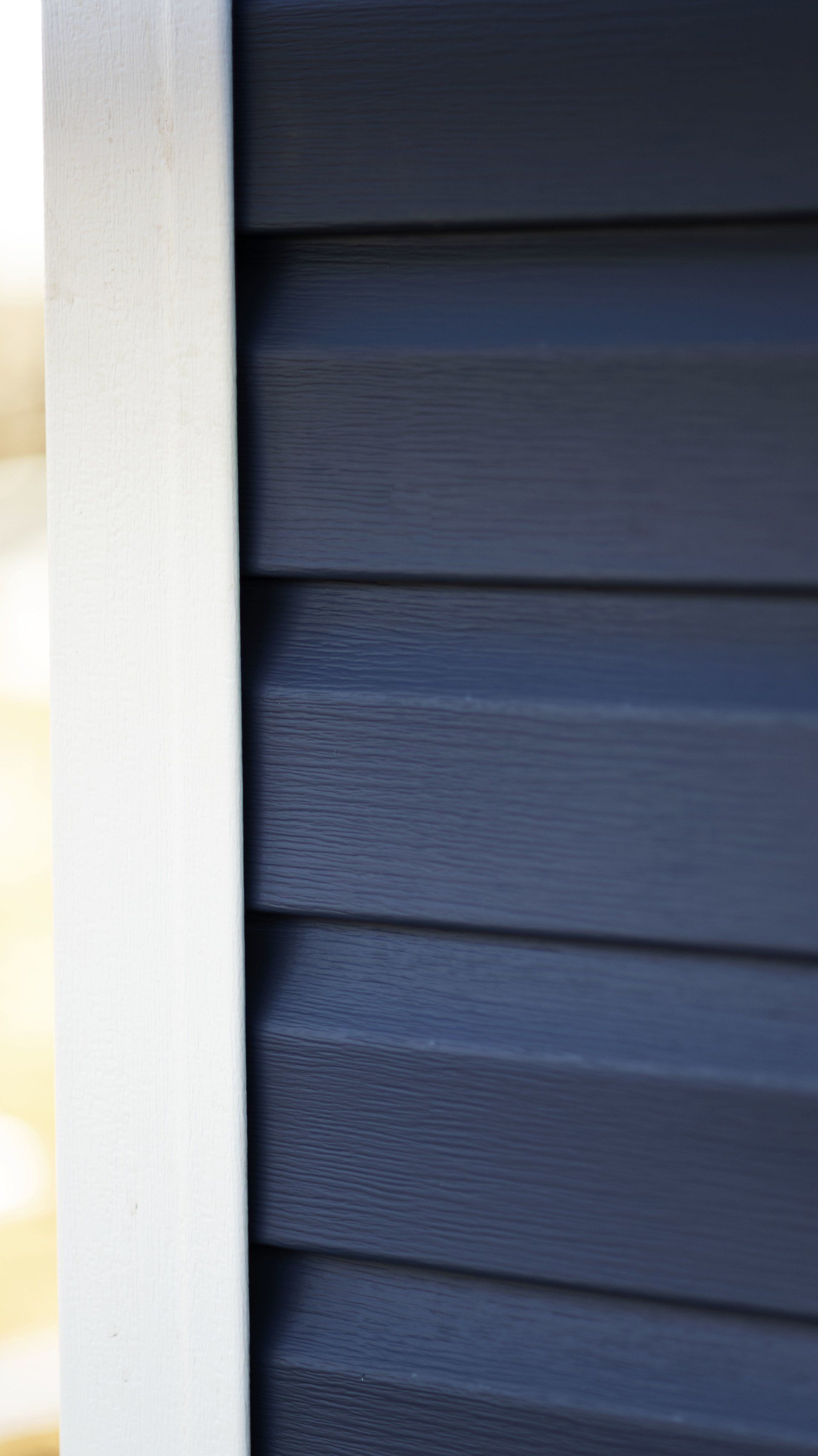 a close up of a blue siding on a house with a white trim .