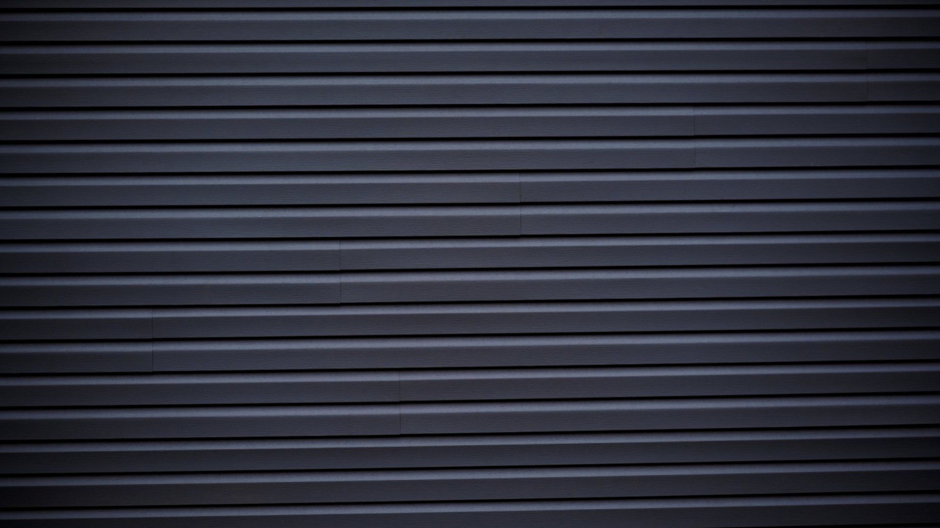 a close up of a black garage door with a striped pattern .