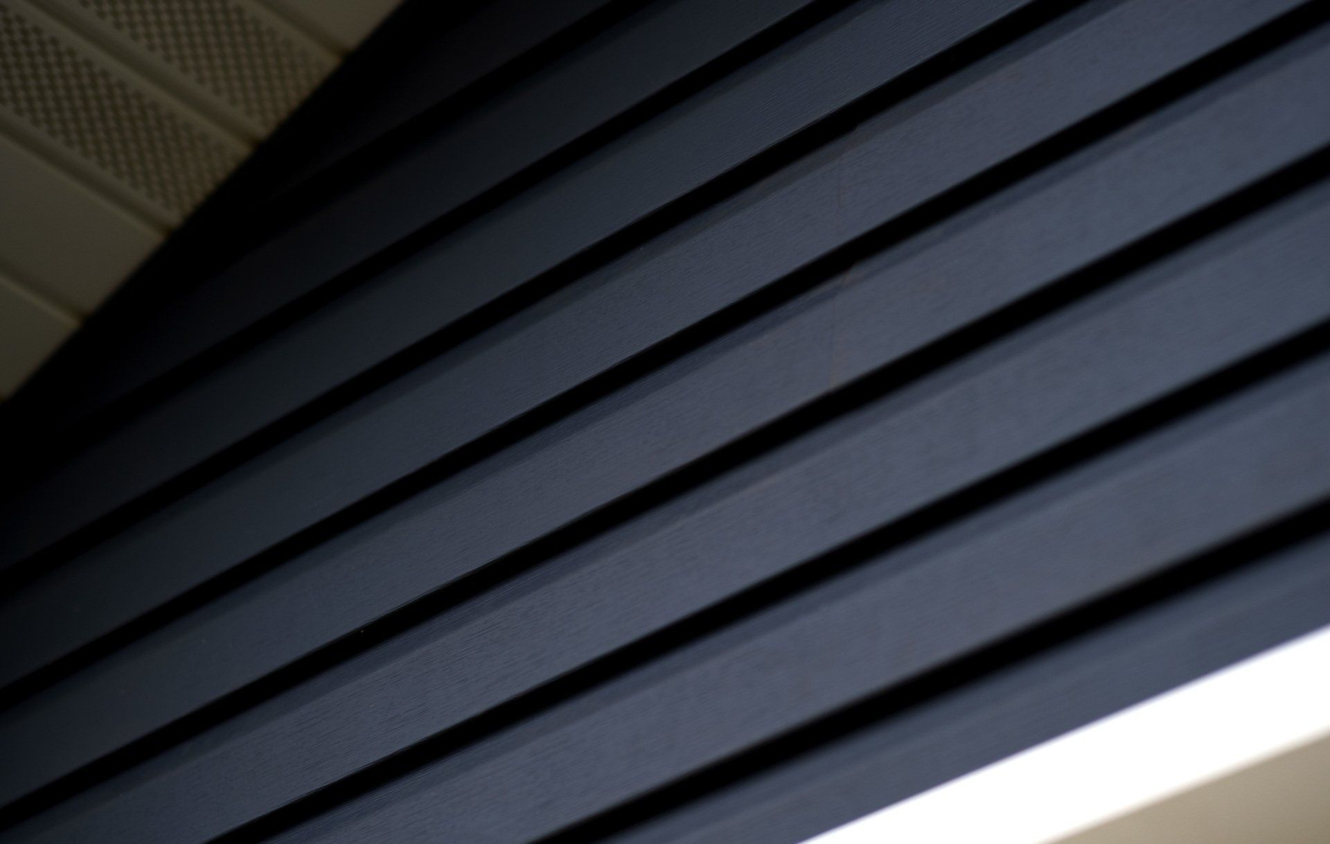 a close up of a black ceiling with a light shining through it .