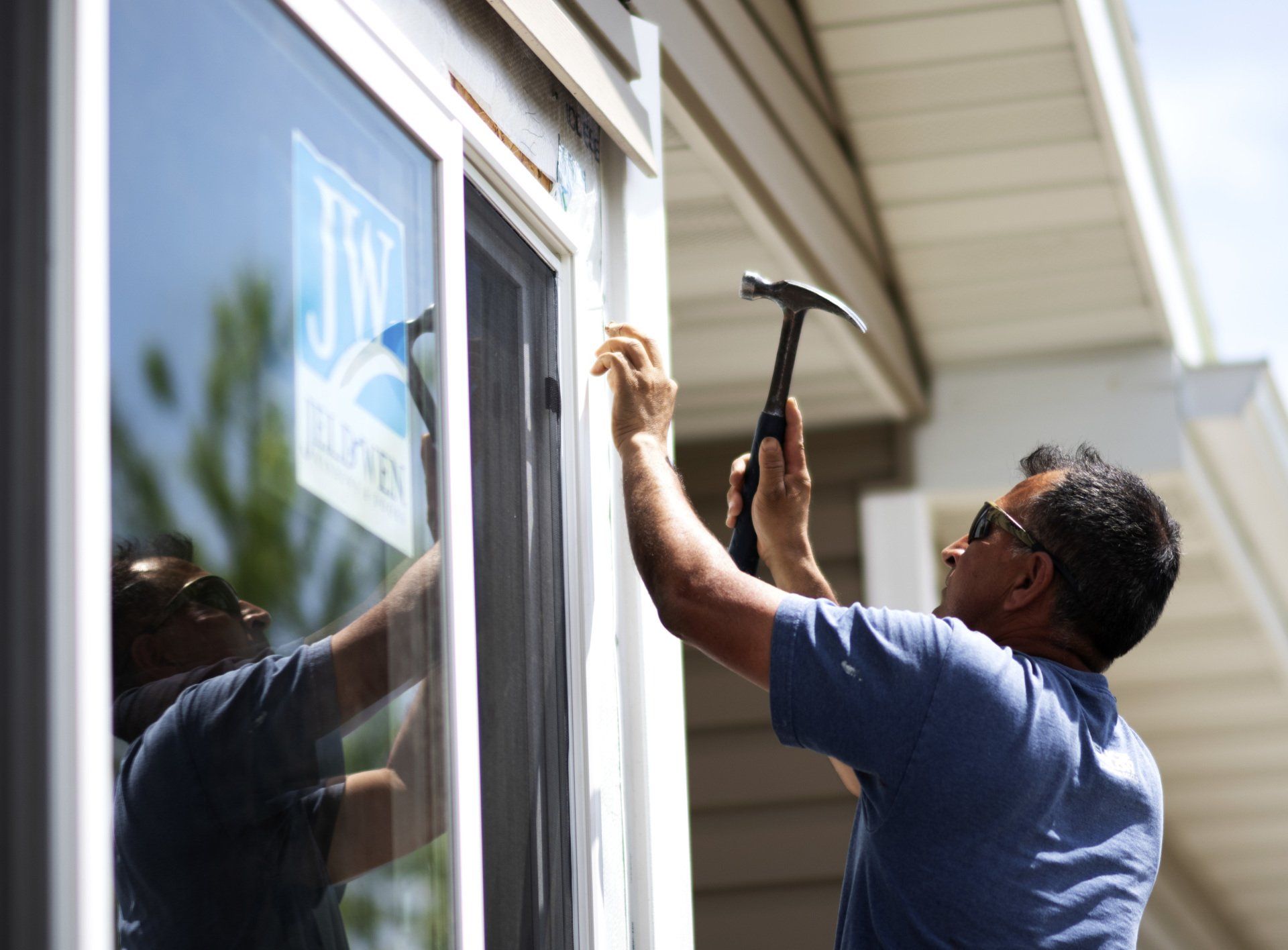 a man is fixing a window with a hammer .