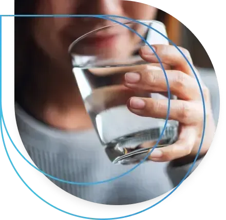 Person drinking water from a clear glass.
