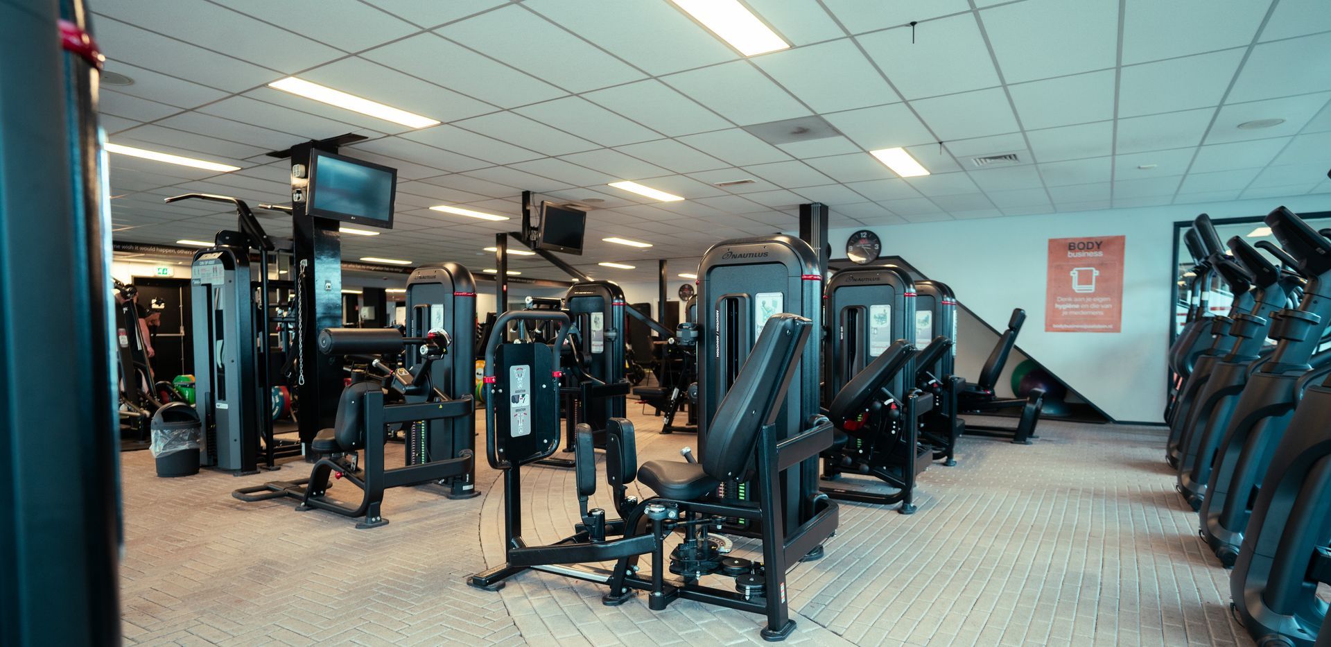 een fitnessruimte met een tv aan het plafond