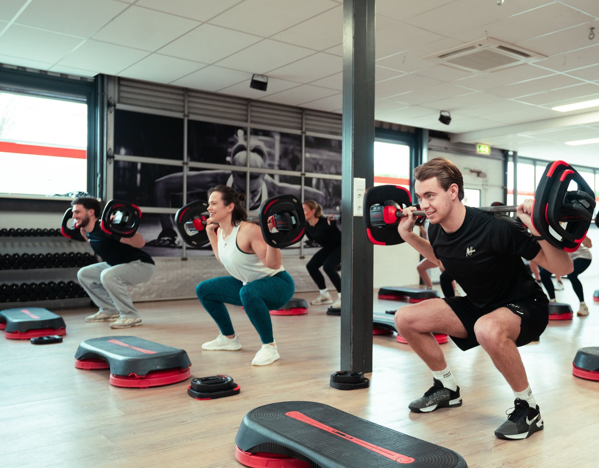 een groep mensen doet plankoefeningen in een sportschool.