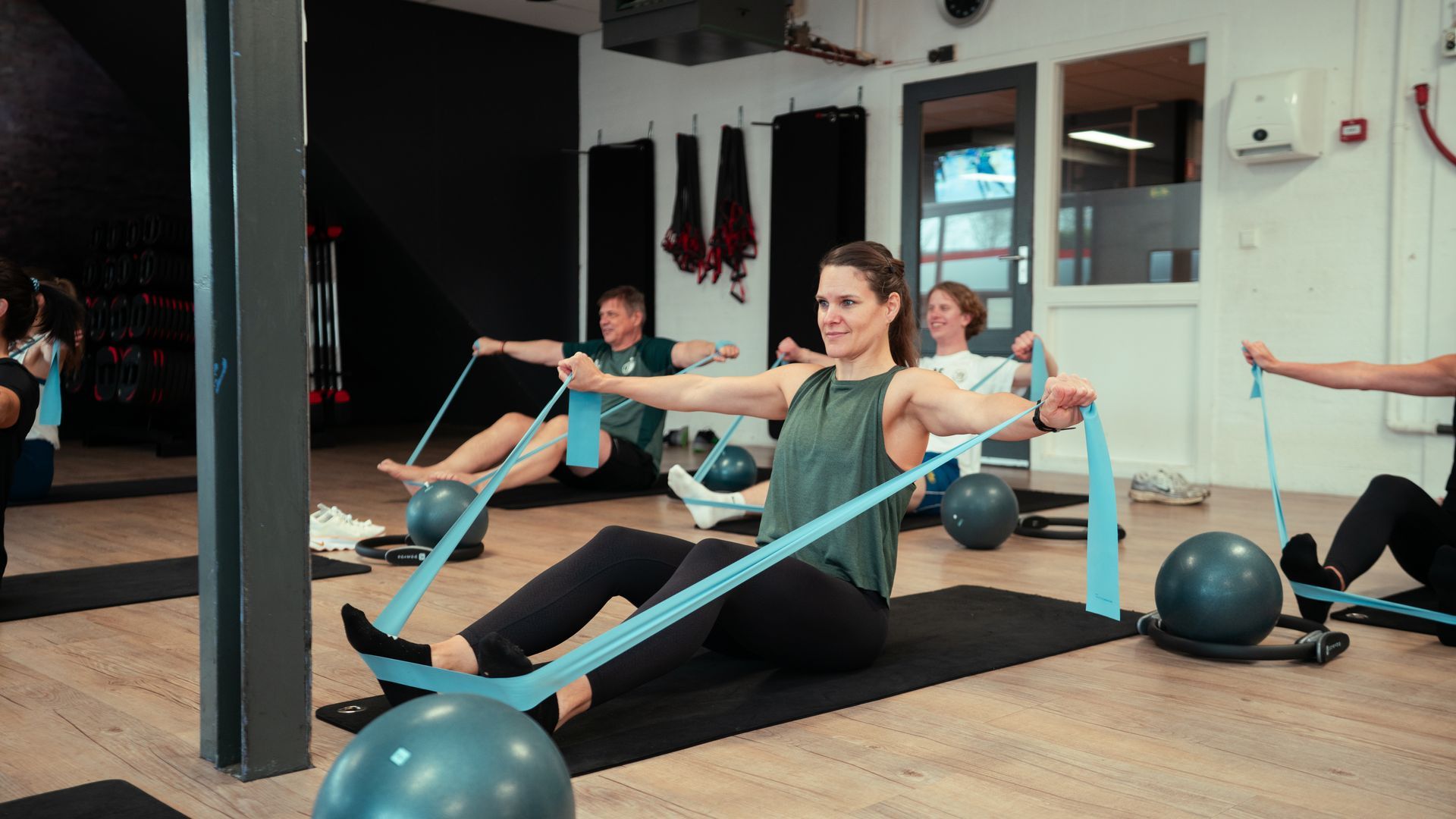 een groep mensen doet samen yoga in een sportschool.