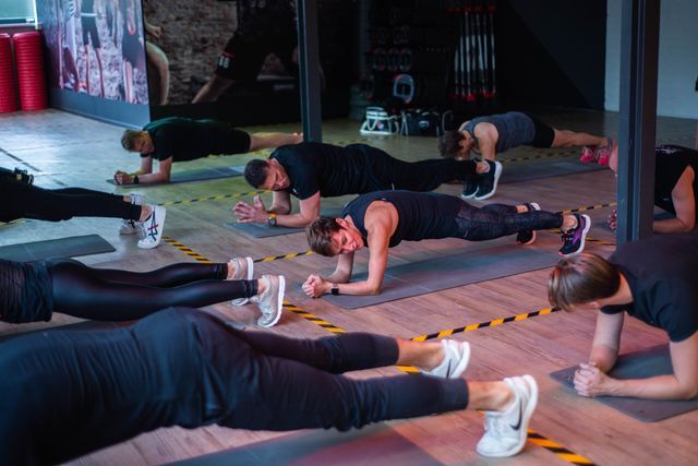 een groep mensen doet plankoefeningen in een sportschool.