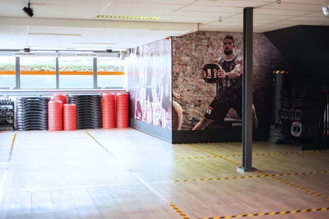 een lege sportschool met een foto van een man aan de muur.