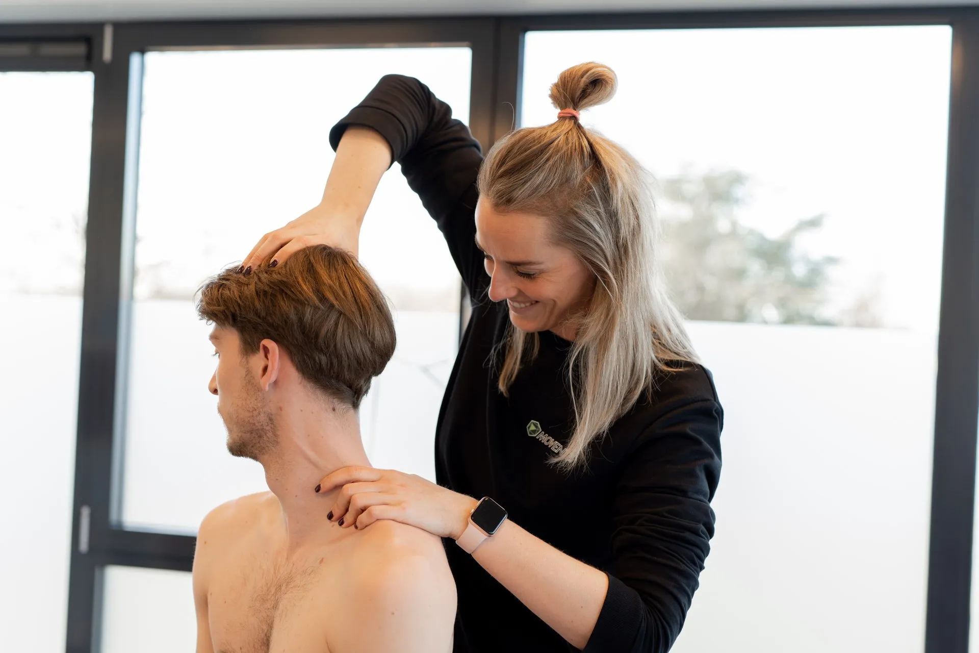 een vrouw geeft een man een massage in zijn nek.