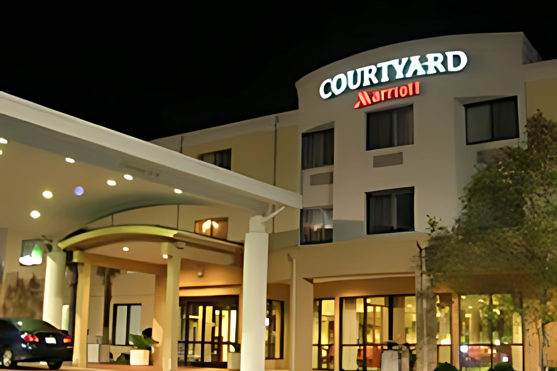 A courtyard marriott hotel is lit up at night