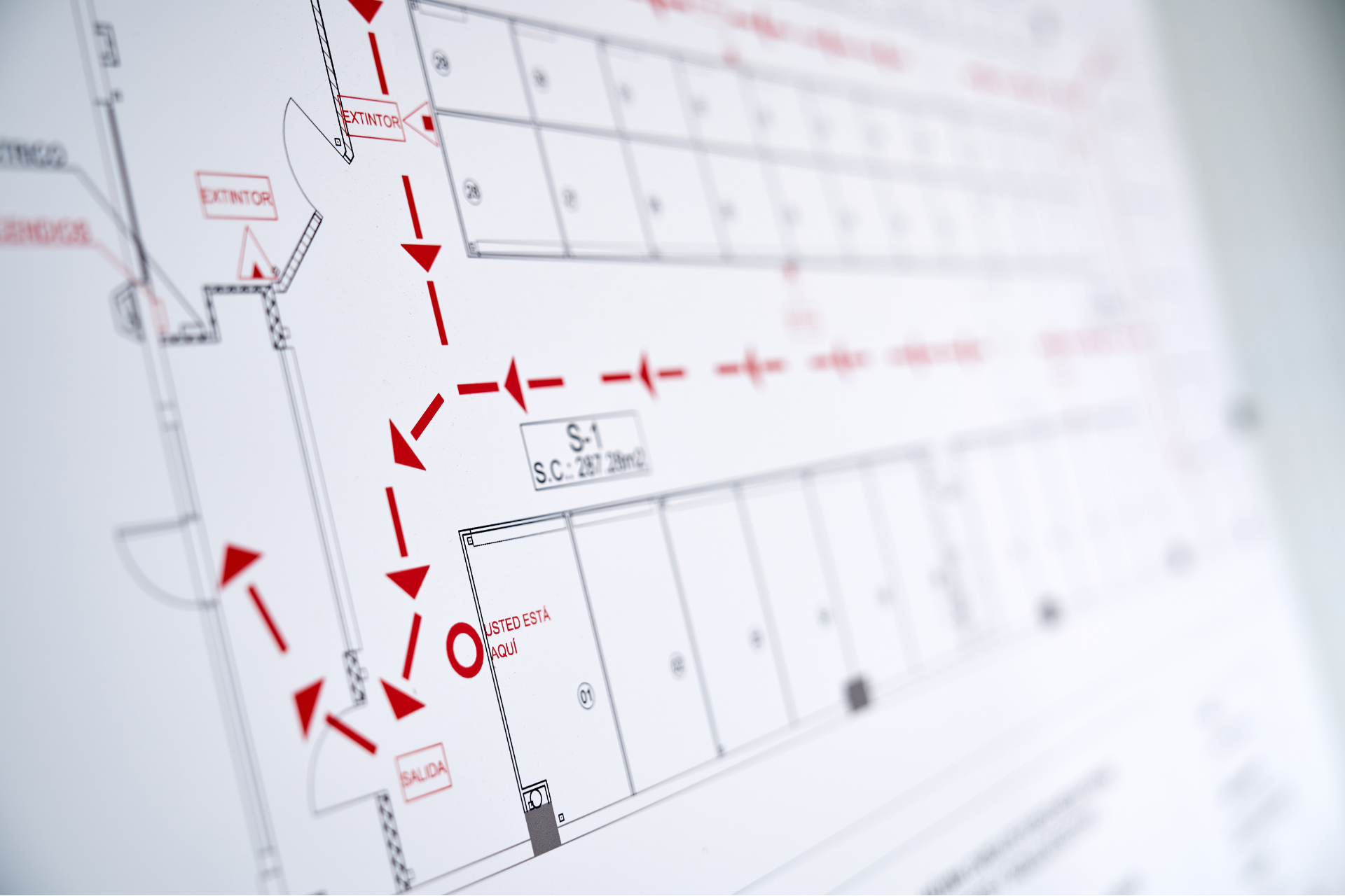 A close up of a floor plan of a building with red arrows pointing in different directions.