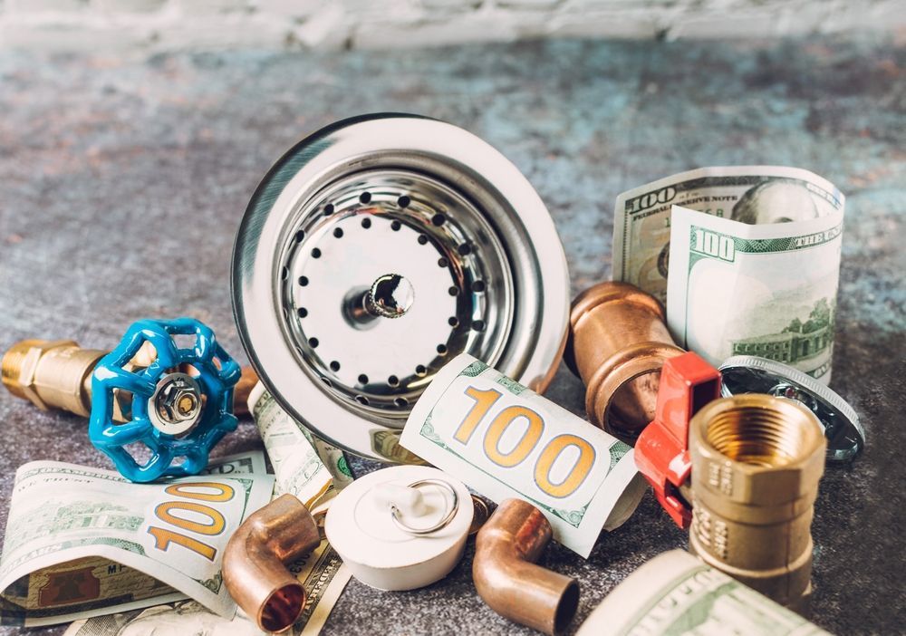 A pile of plumbing parts and money on a table.