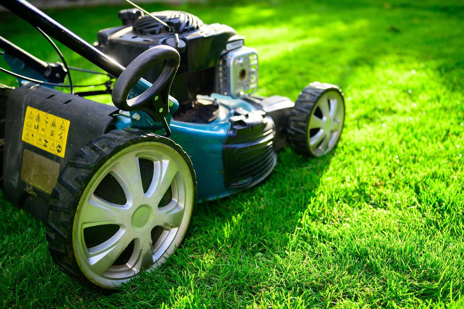 Lawn Mower On Green Grass In A Sunny Day — Little Valley, NY — TRI R SERVICES