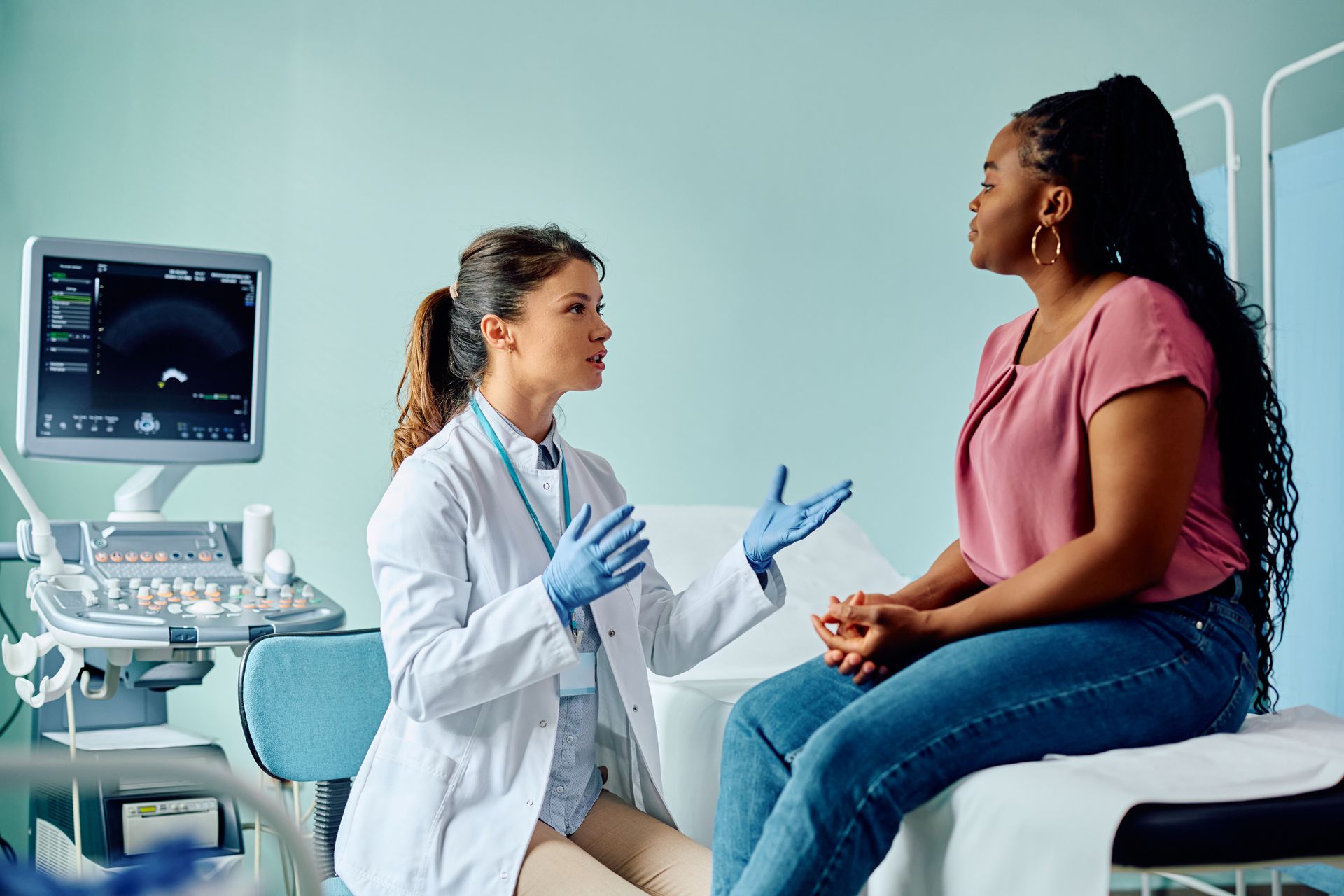 A woman communicating with her doctor in a medical examination room.