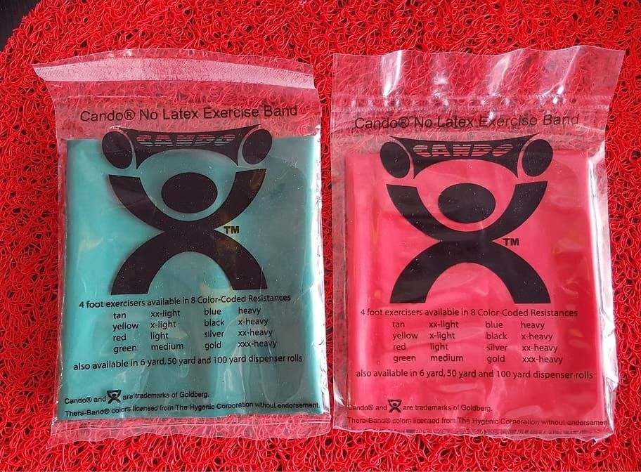 Two Bags of Exercise Bands Are Sitting on a Red Mat — Anderson Family Chiropractic Health Centre in Mount Pleasant, QLD