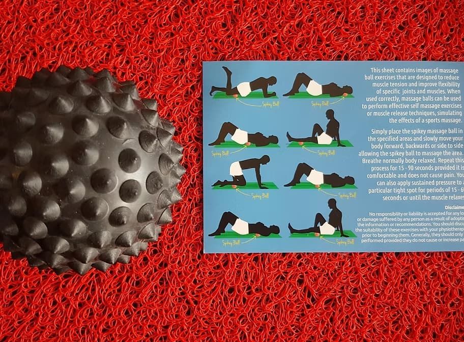 A Black Ball and a Card With Yoga Poses on It — Anderson Family Chiropractic Health Centre in Mount Pleasant, QLD