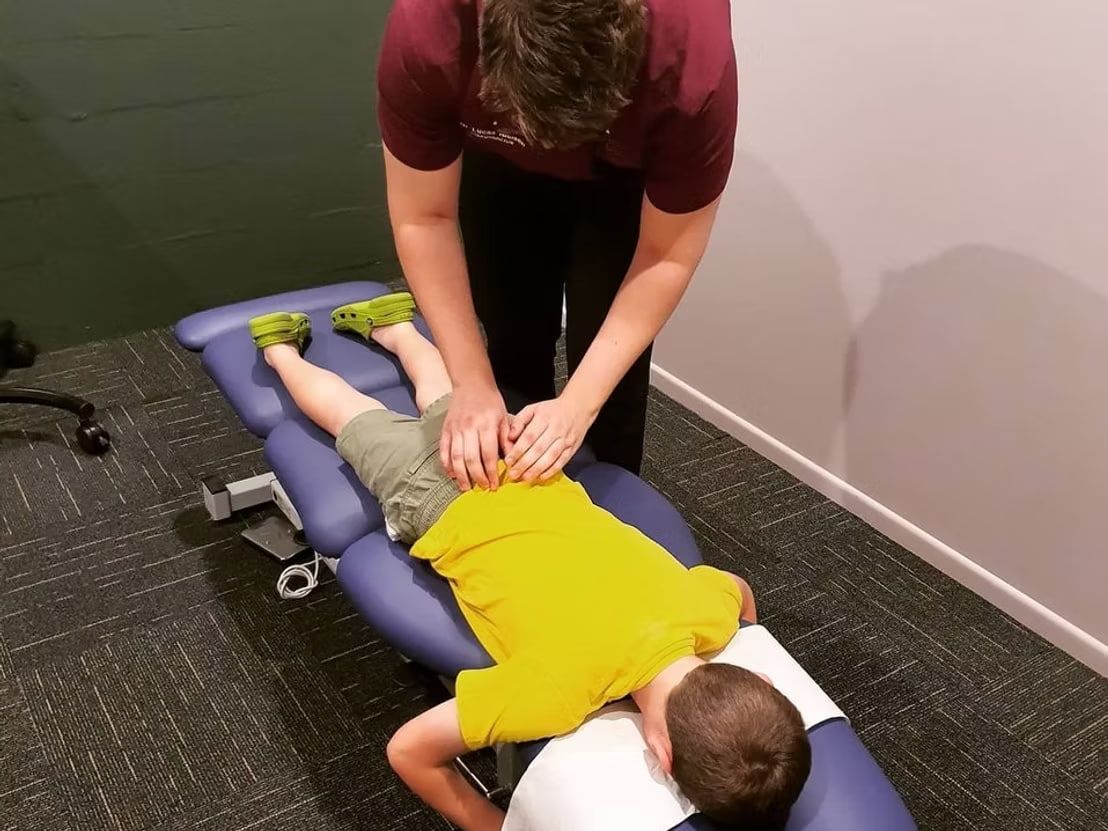 A Young Boy is Getting an Adjustment From a Chiropractor — Anderson Family Chiropractic Health Centre in Mount Pleasant, QLD