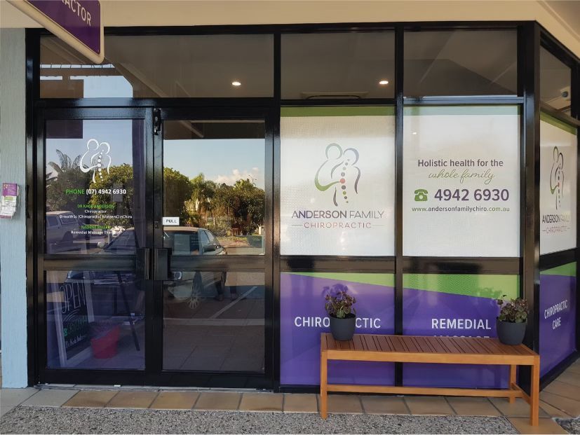 A Purple and Green Building With a Bench in Front of It — Anderson Family Chiropractic Health Centre in Mount Pleasant, QLD