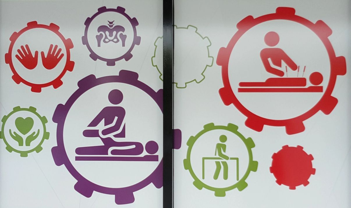 A Purple and Red Icon of a Person Giving a Massage — Anderson Family Chiropractic Health Centre in Mount Pleasant, QLD
