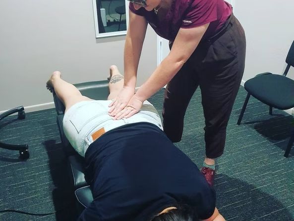 A Woman is Giving a Person a Massage on Their Back — Anderson Family Chiropractic Health Centre in Mount Pleasant, QLD