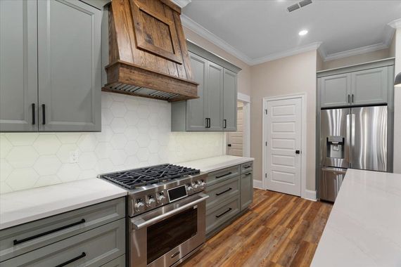 A kitchen with stainless steel appliances and gray cabinets.