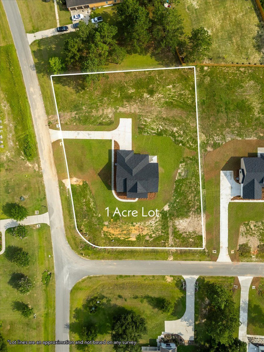 An aerial view of a house on a lot in a residential area.