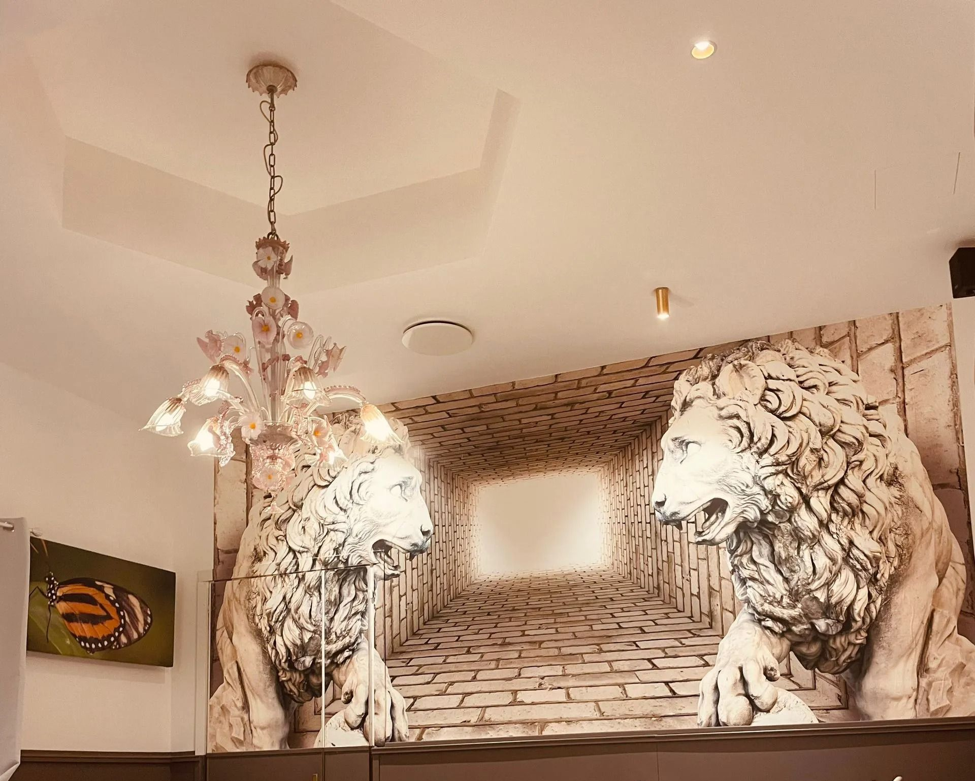 Sala con tavoli apparecchiati per un pasto. Un lampadario di cristallo pende dal soffitto. Tovaglie bianche e sedie blu.