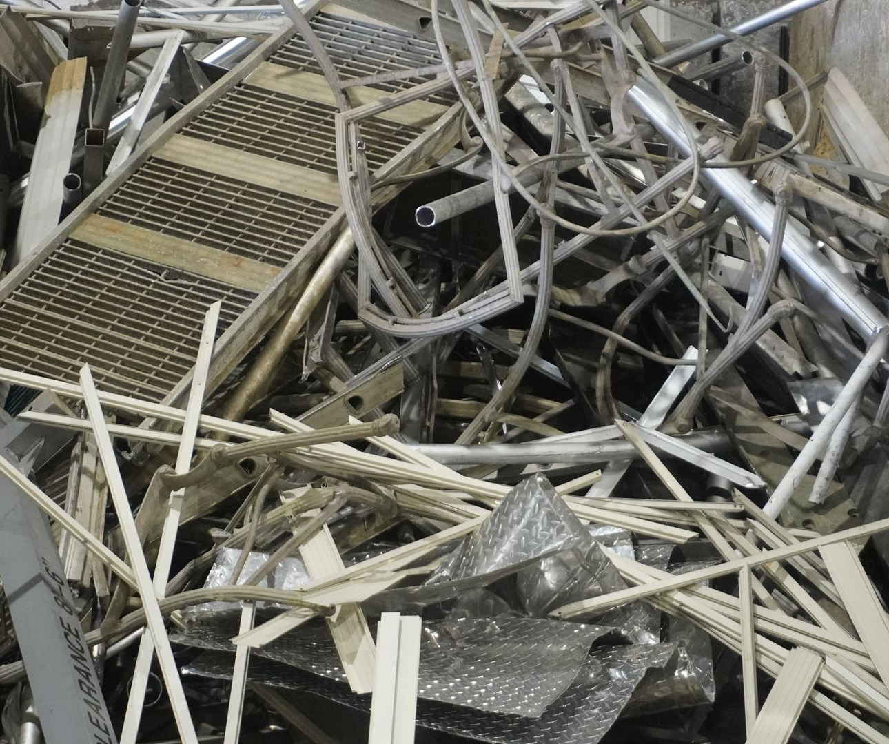 Pile of bent metal scaffolding and debris in a damaged industrial area