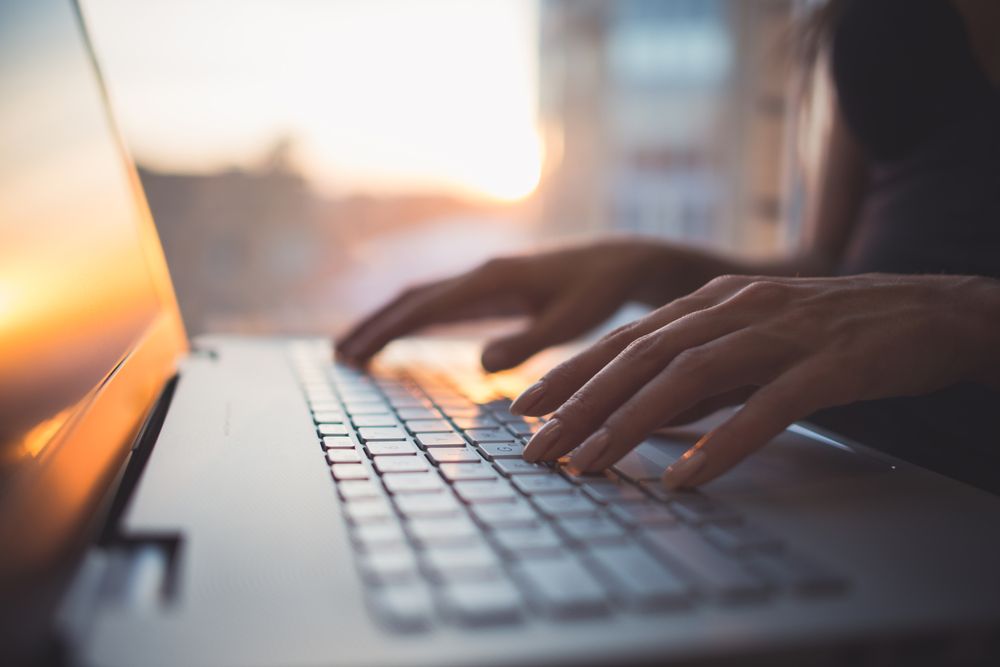 A Person is Typing on a Laptop Computer at Sunset — Complete Computing Consultancy In Hervey Bay, QLD
