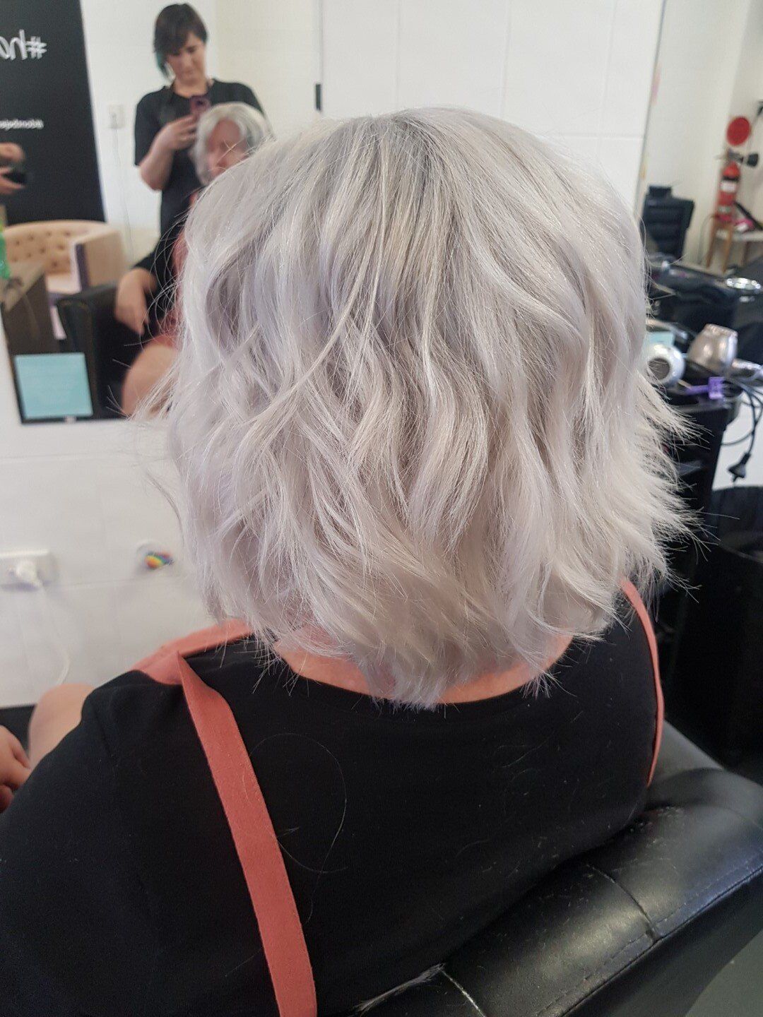 Back view of short wavy platinum gray hair.
