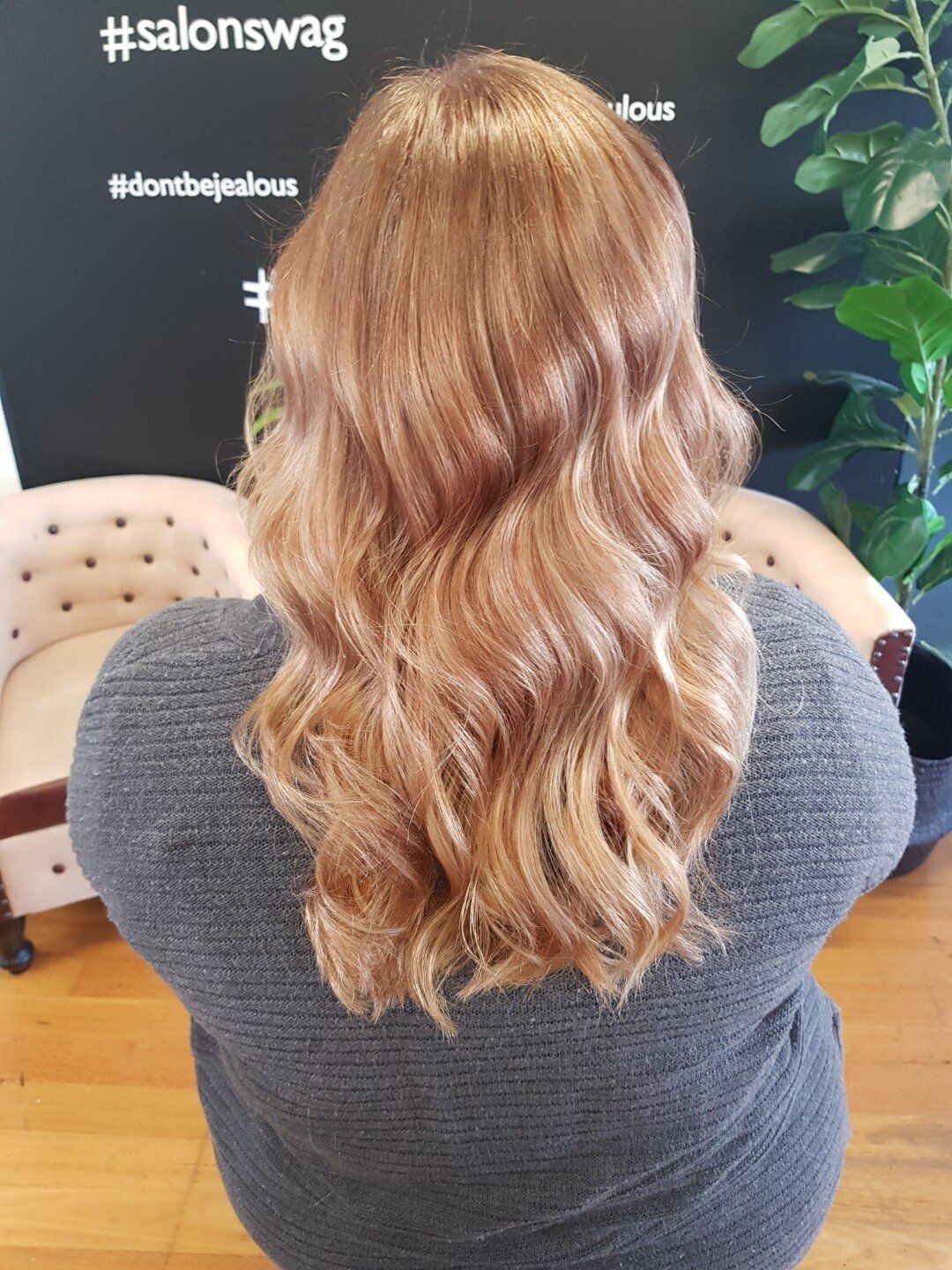 Long blonde hair viewed from the back with natural waves.
