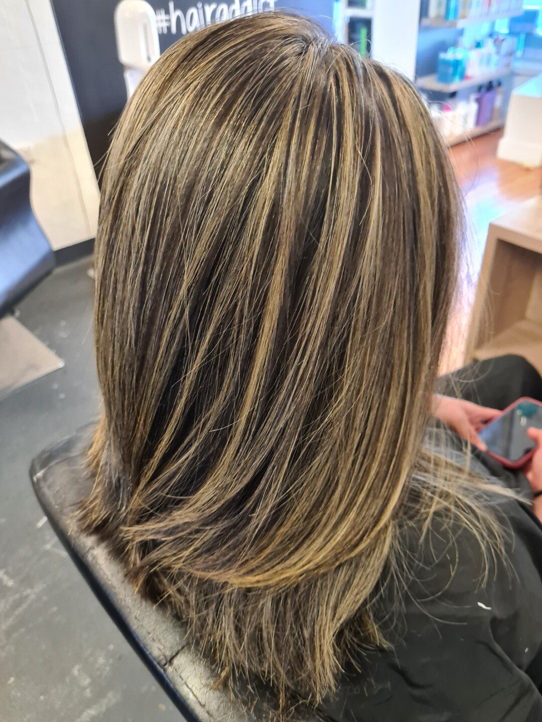 Straight dark hair with golden blonde highlights.
