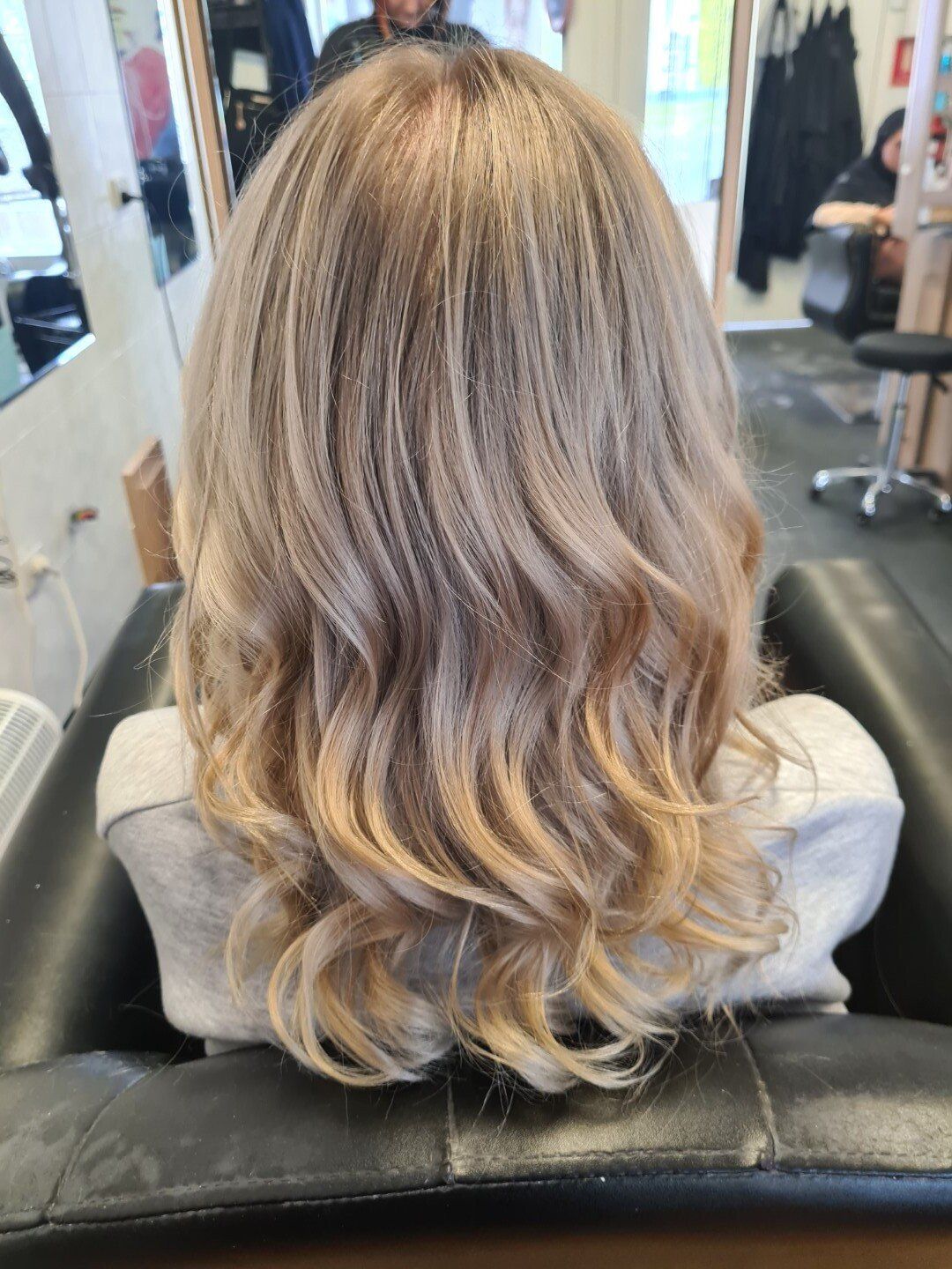 Back view of curly hair with blonde highlights.
