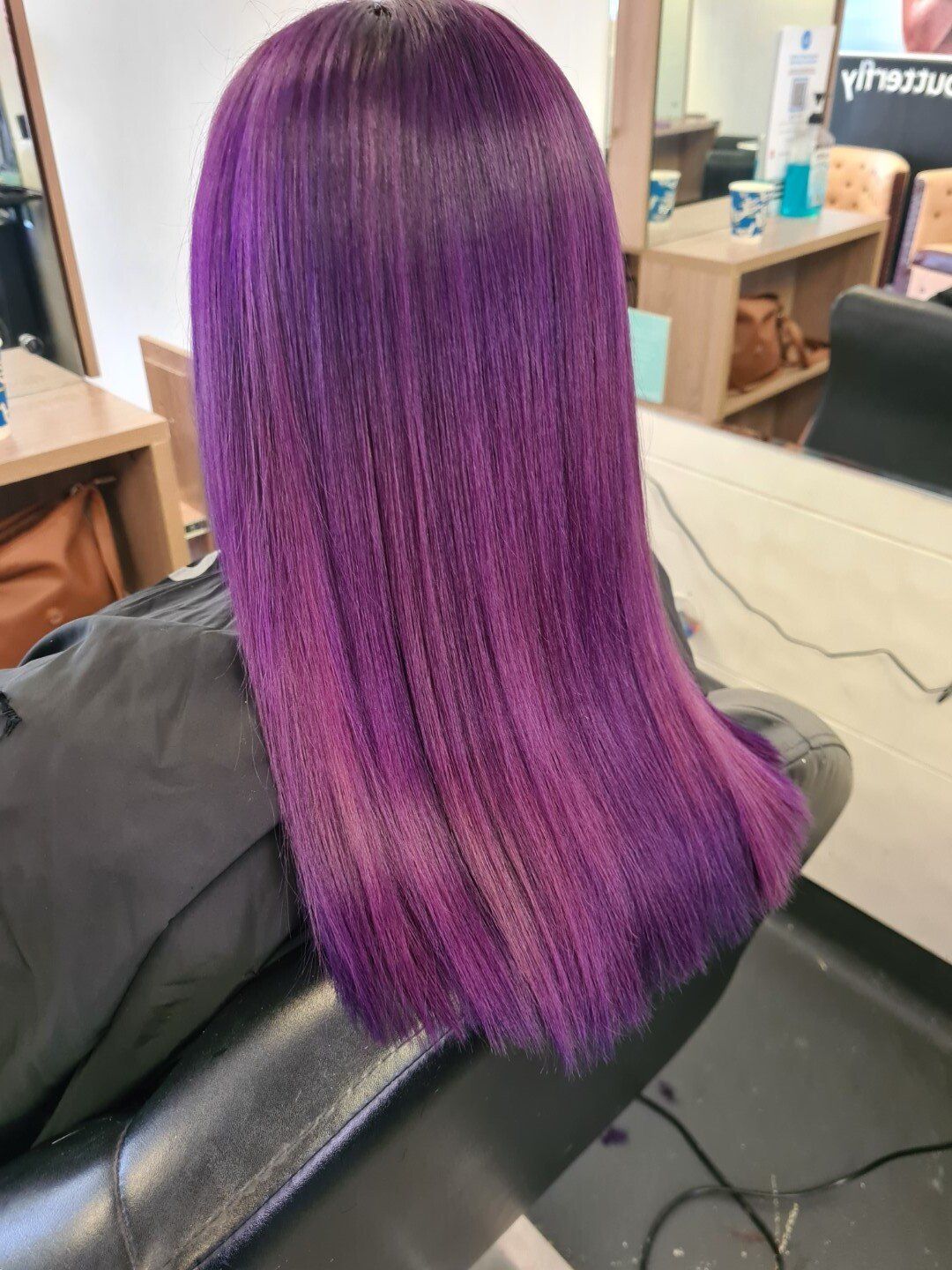 Close-up of dark roots transitioning to light purple ends.
