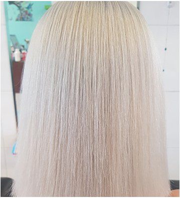 A close up of a woman's blonde medium hair in a salon.