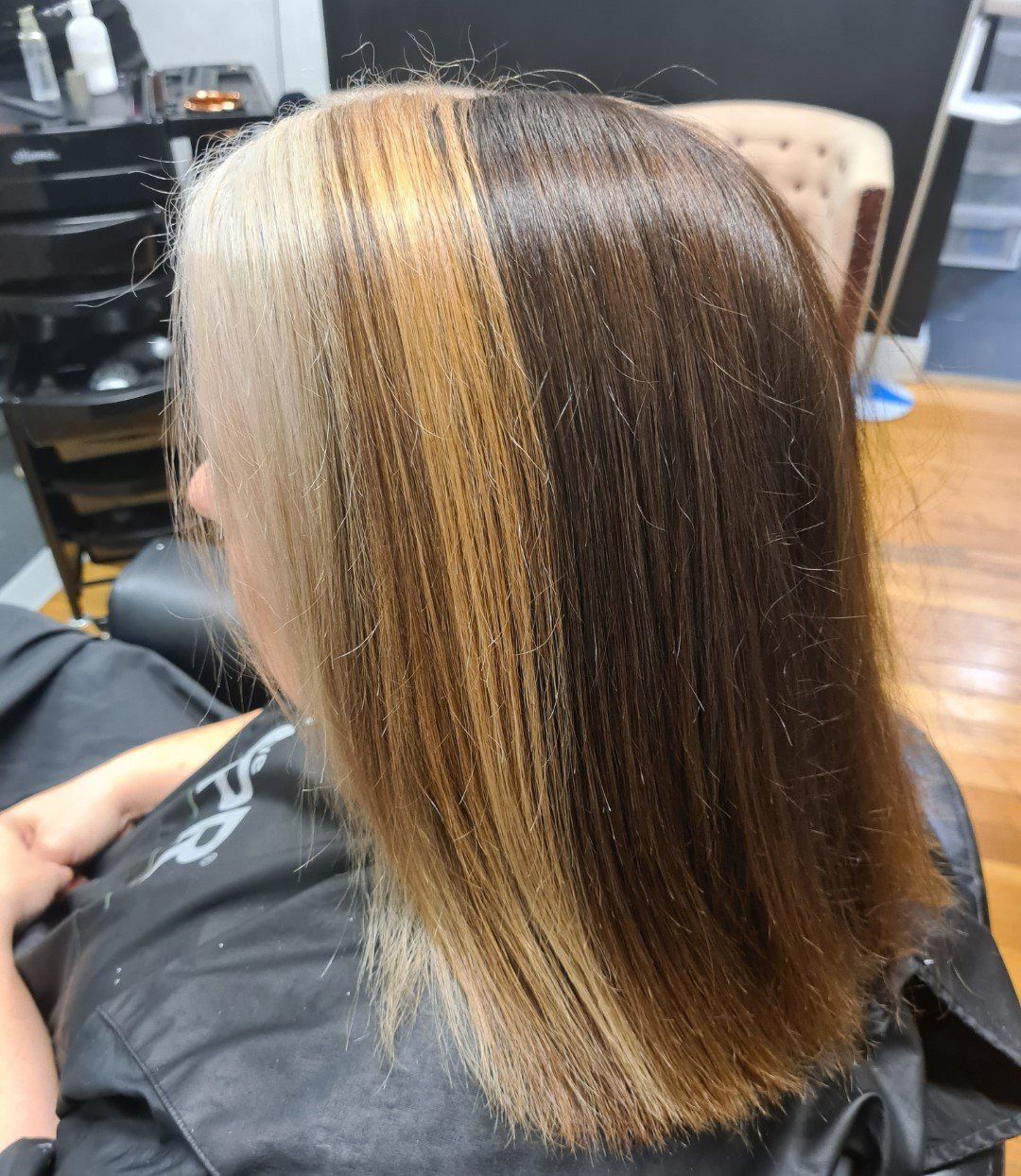 A woman is getting her hair cut in a salon