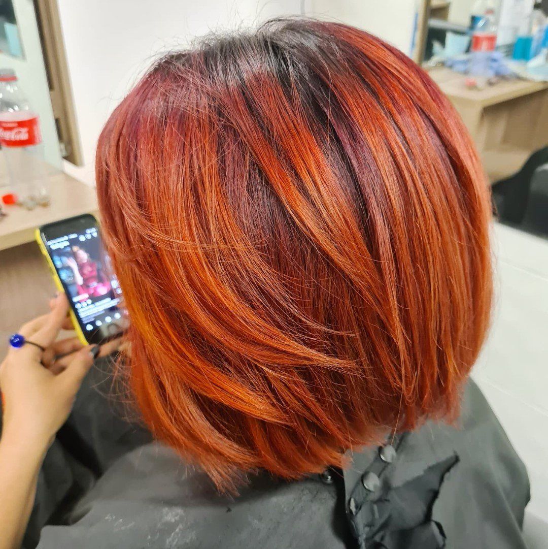Rear view of hair with vibrant red and orange color.
