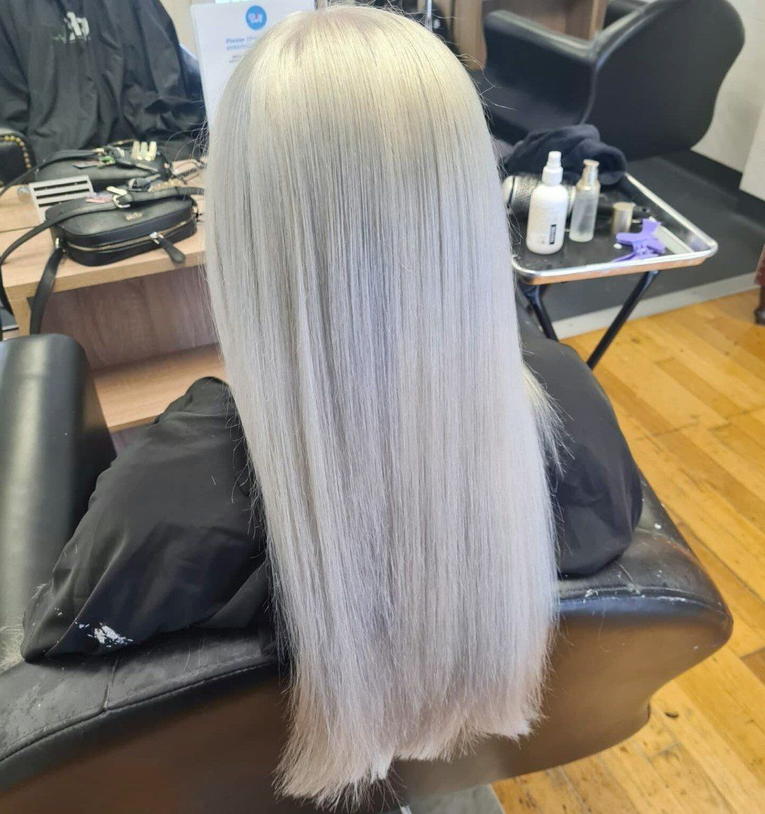 A back view of long, straight platinum blonde hair.
