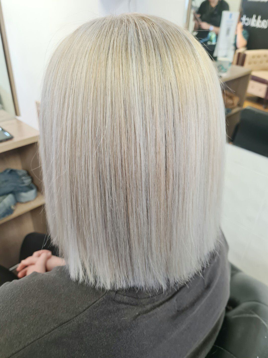 Stylish blonde woman with bob haircut at salon
