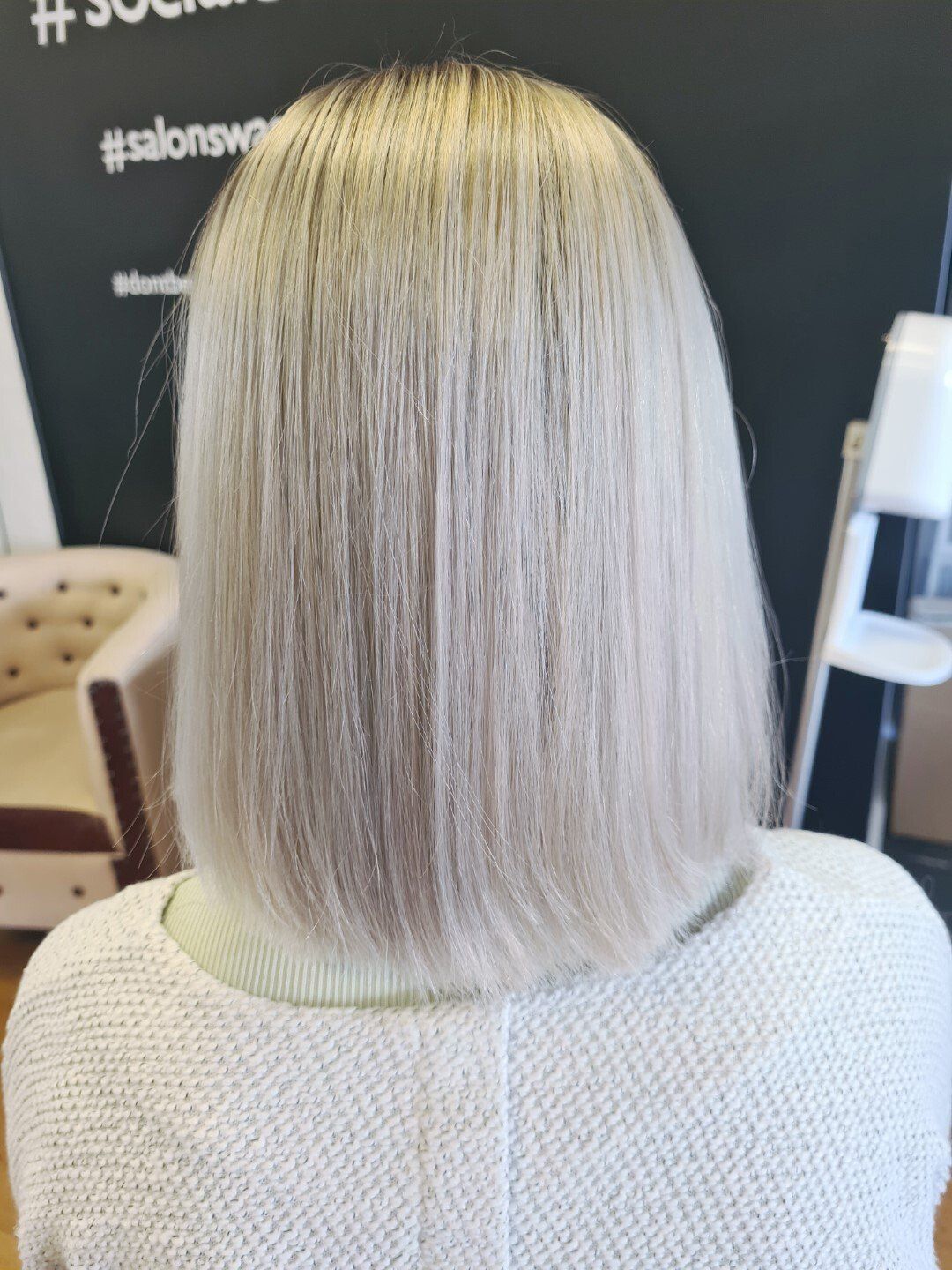 A blonde bob hairstyle of a girl with a white sweater
