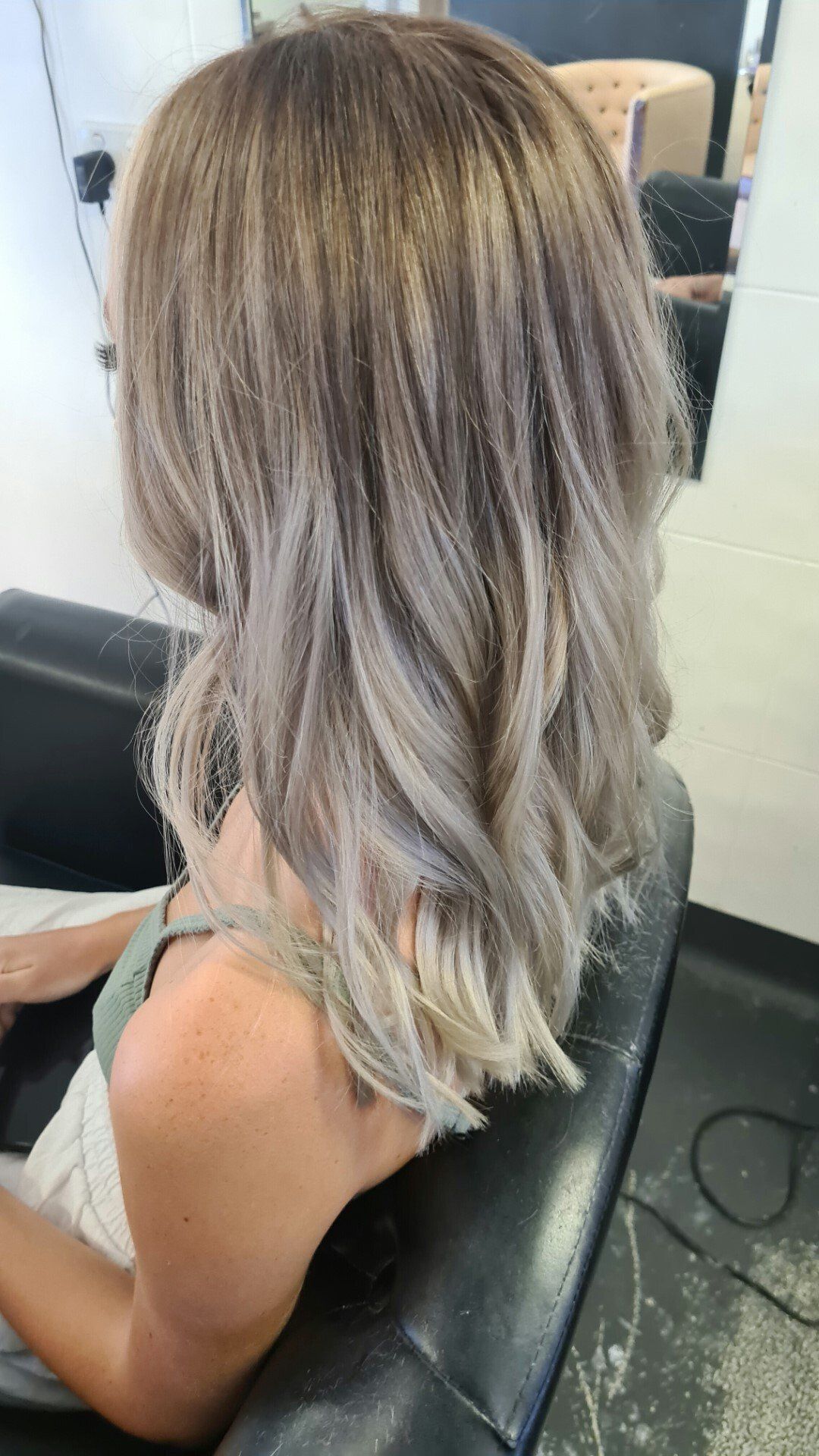 A woman with blonde hair in a chair.
