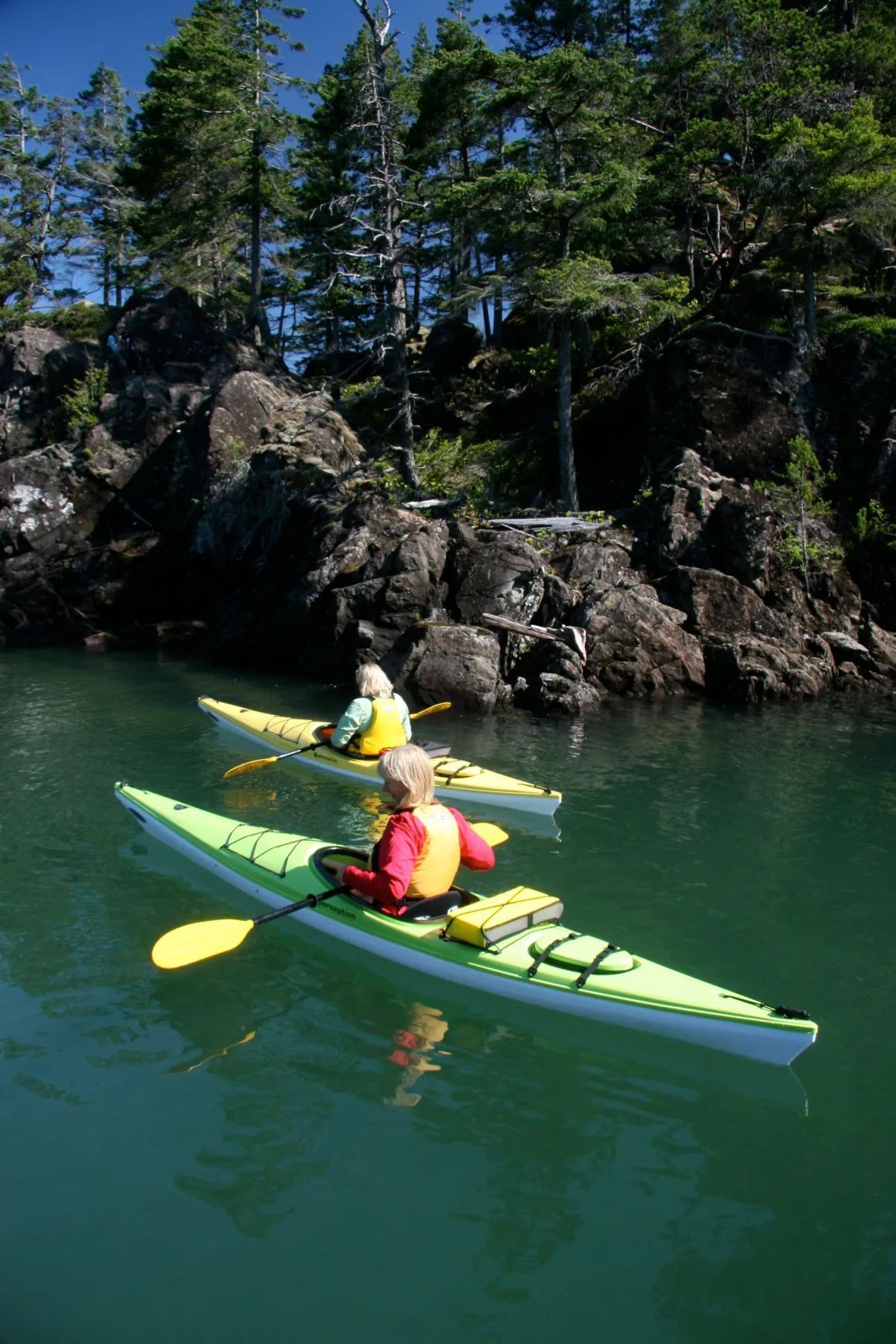 A couple of people in kayaks in a body of water