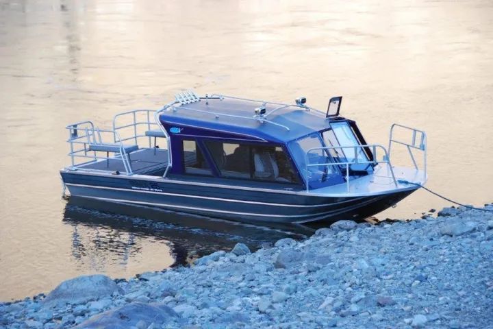 A small boat is tied to the shore of a river